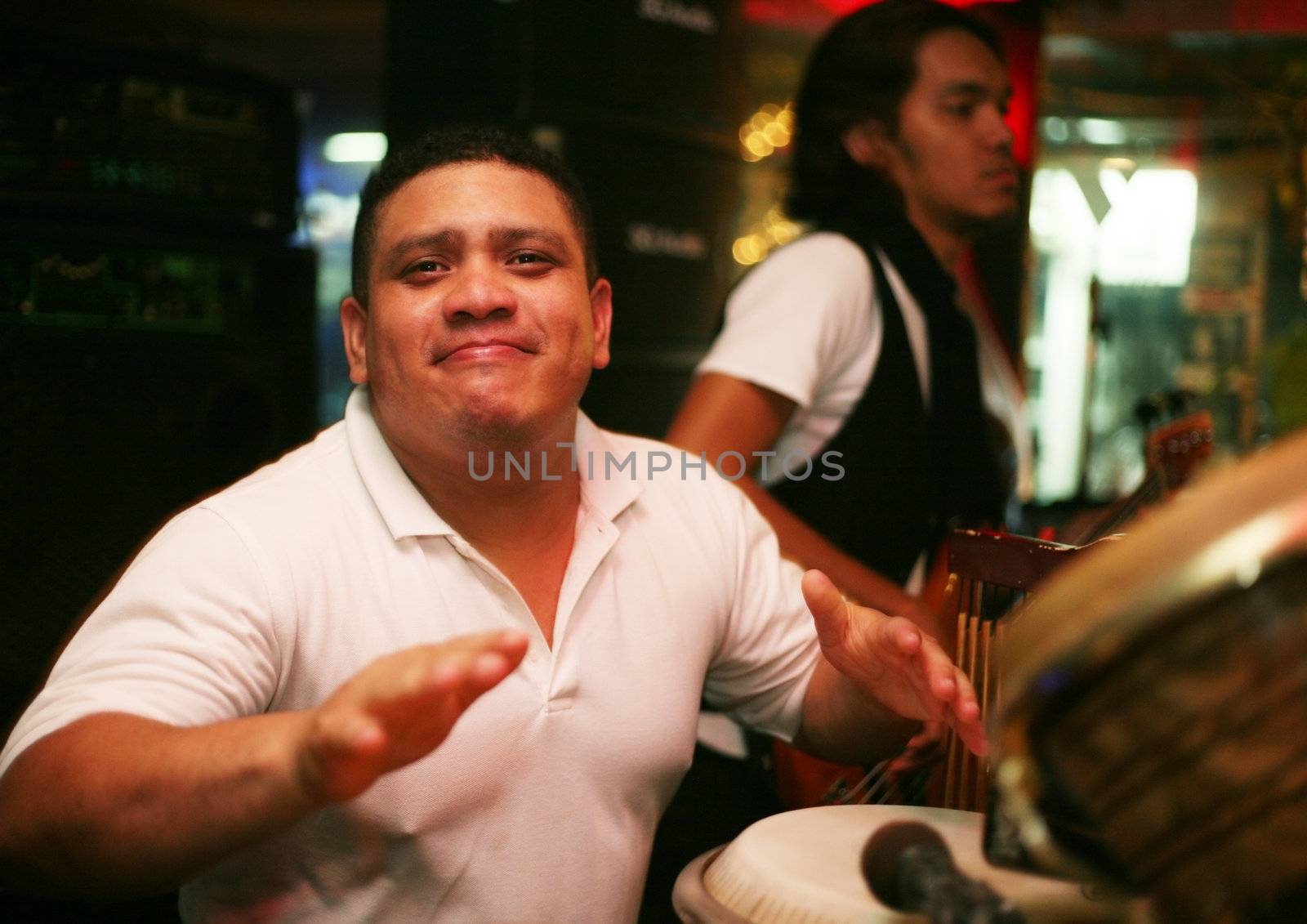 Smiling musician at an alive concert in a night club "La vida loka". Bali. Indonesia