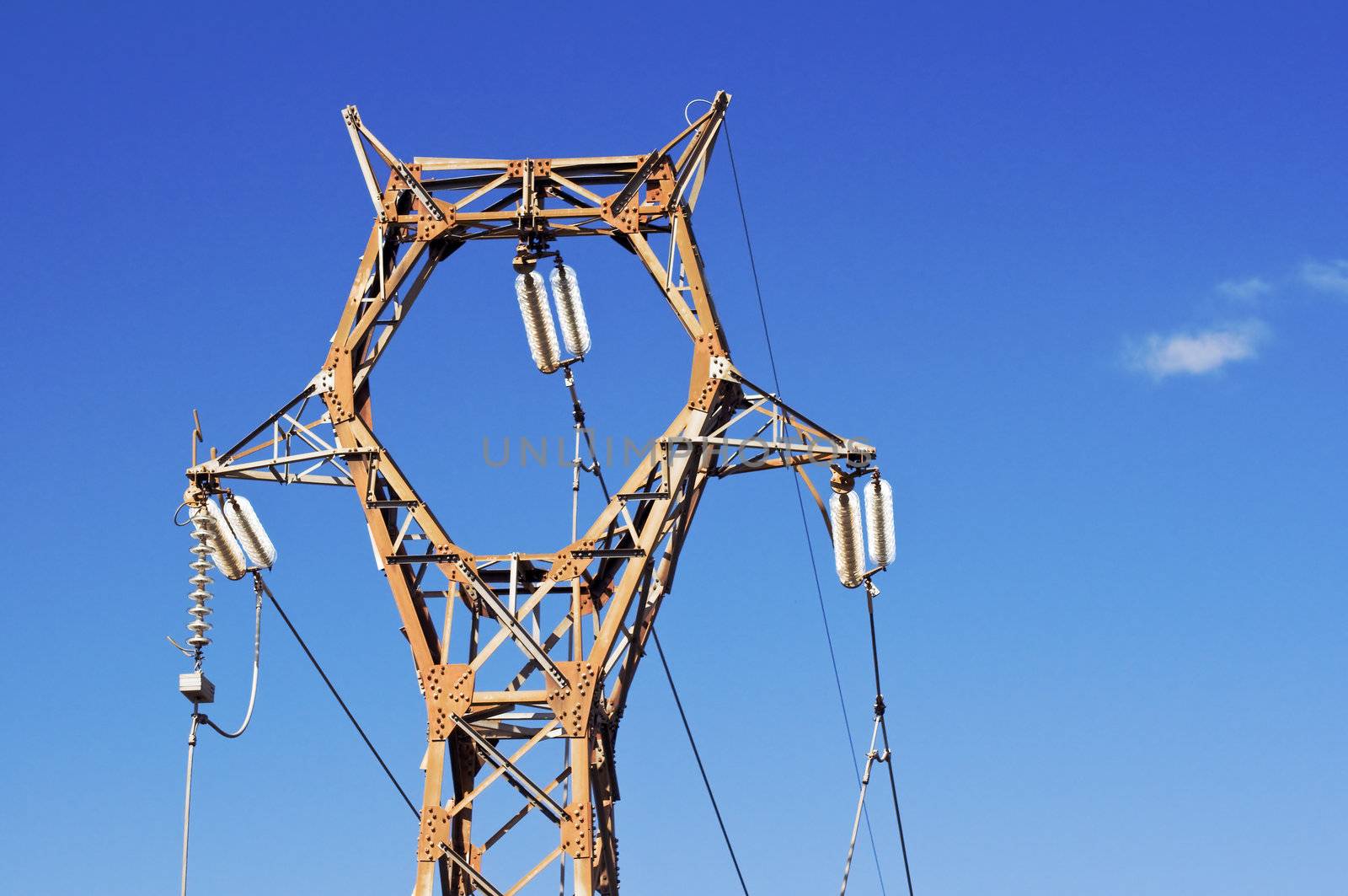 High voltage pylon against blue sky