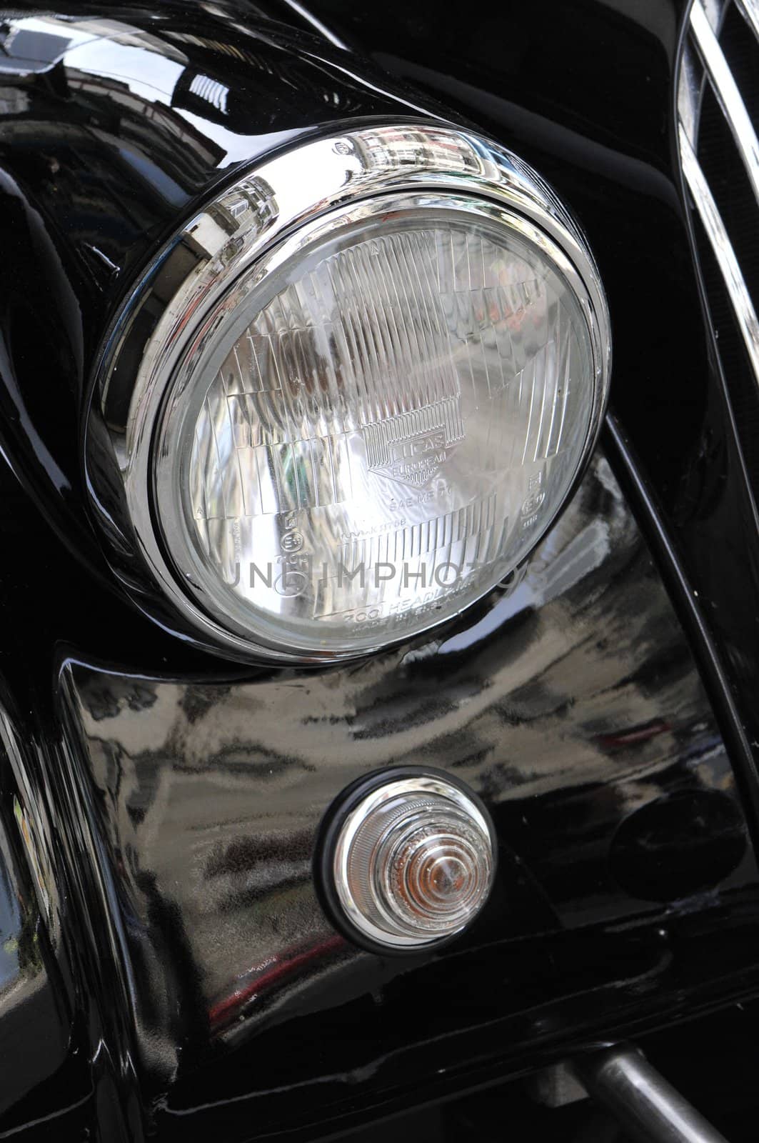 Close-up of an old chromed headlight on a Morgan car by shkyo30