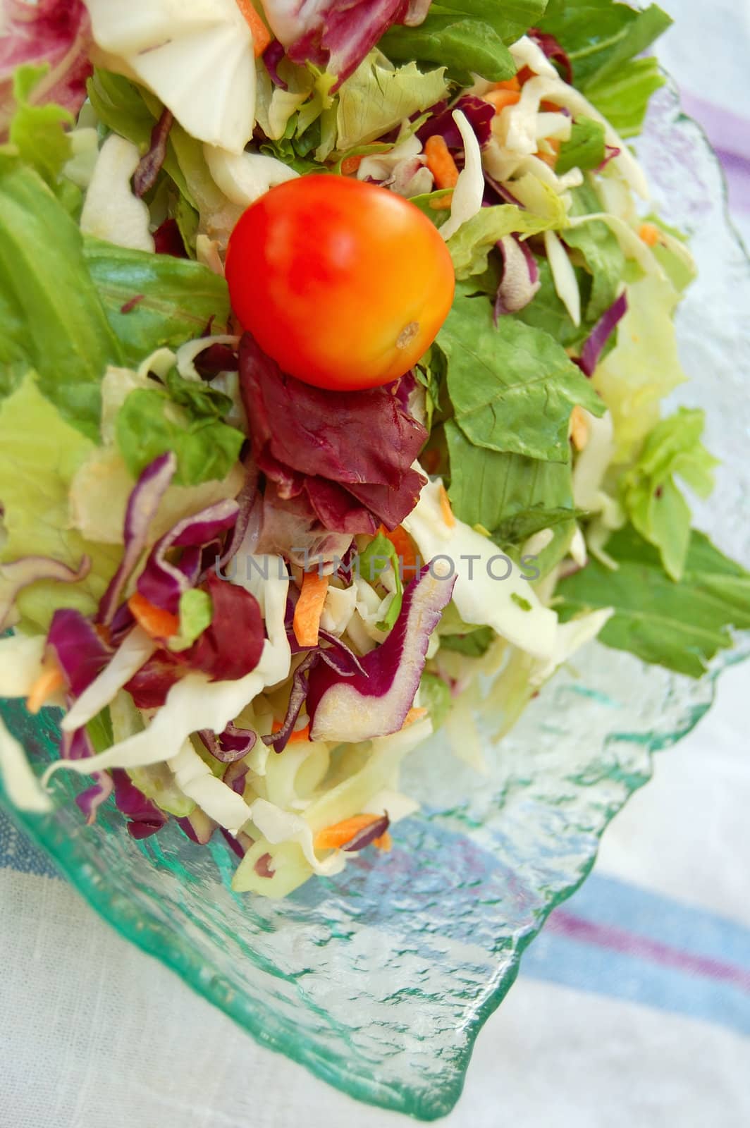 Glass bowl with fresh mixed salad. Raw food background.