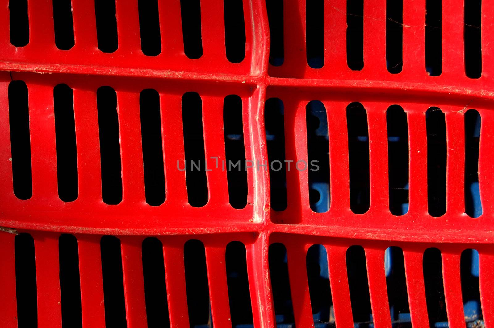Red plastic crate. Fruit packing container detail.