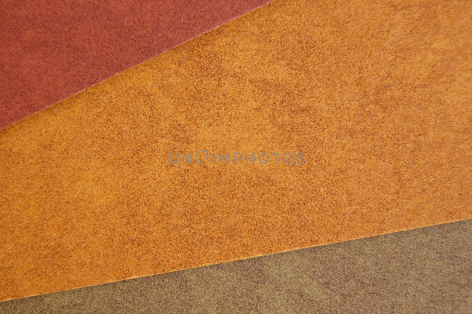 Three different colors of recycled paper. Speckled cardboard background texture.