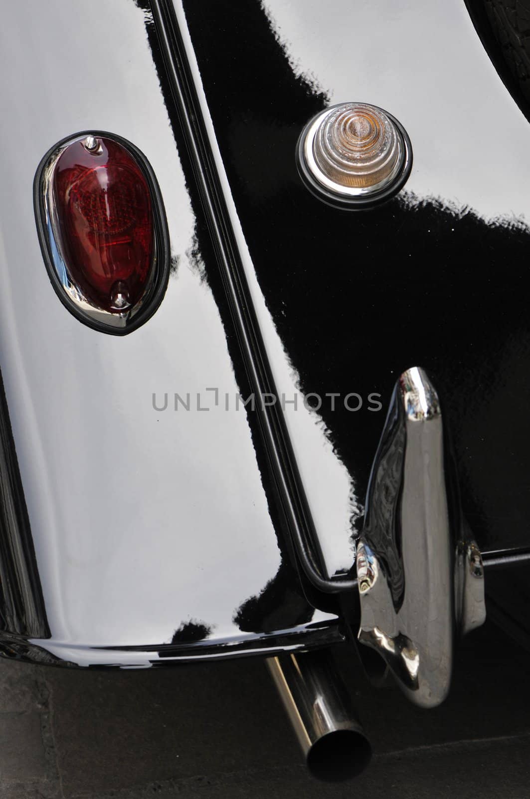 View of an old chromed backup light on a black Morgan car