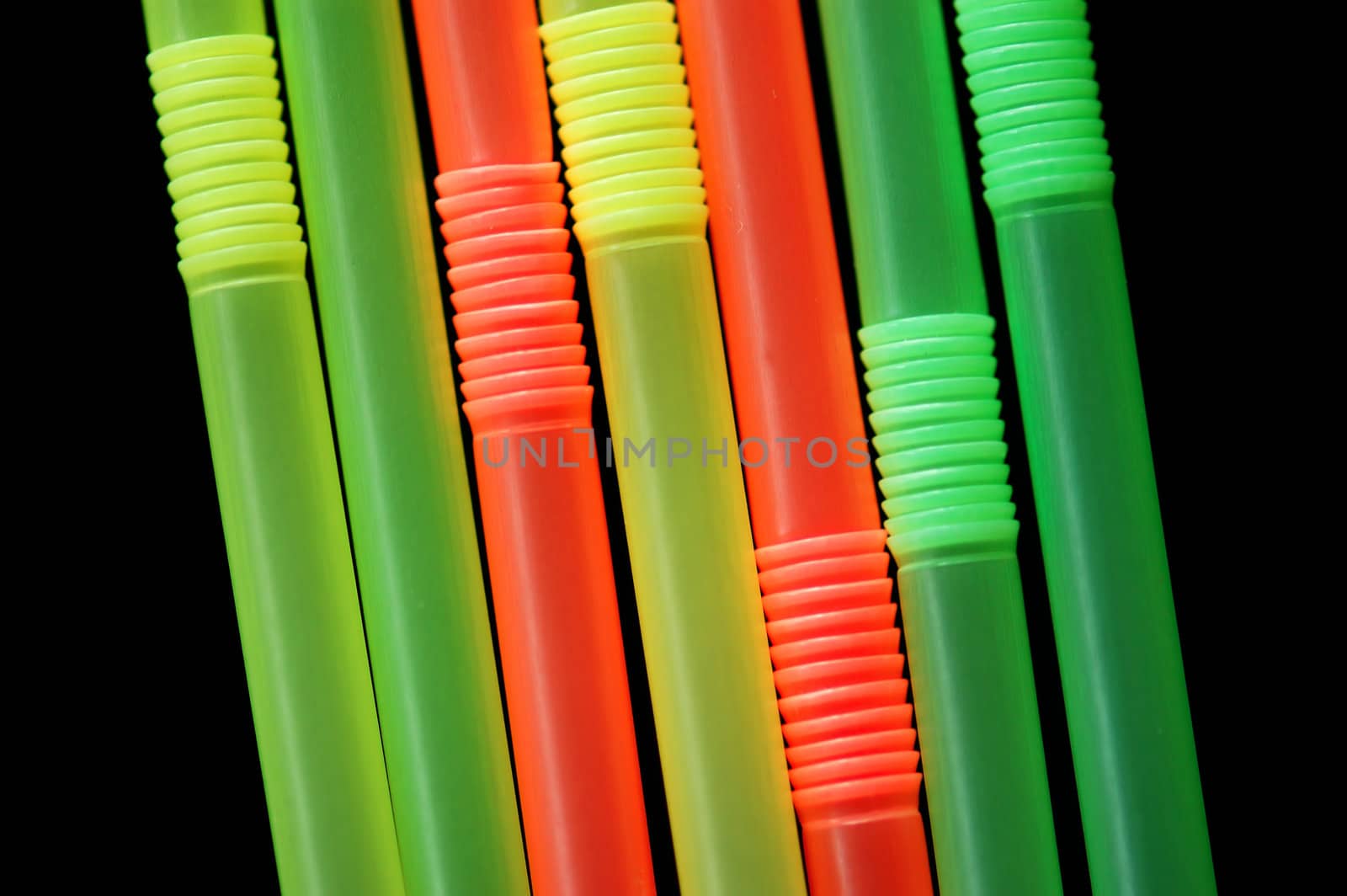 Drinking straws isolated on black background. Abstract pattern.