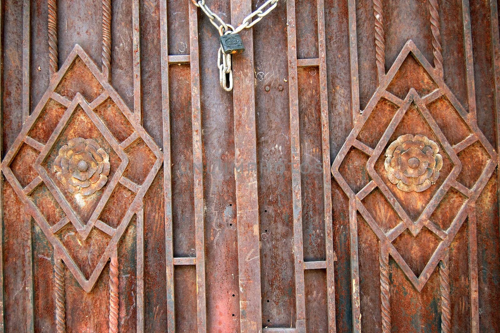 Rusty metal door with floral pattern. Abstract background texture.