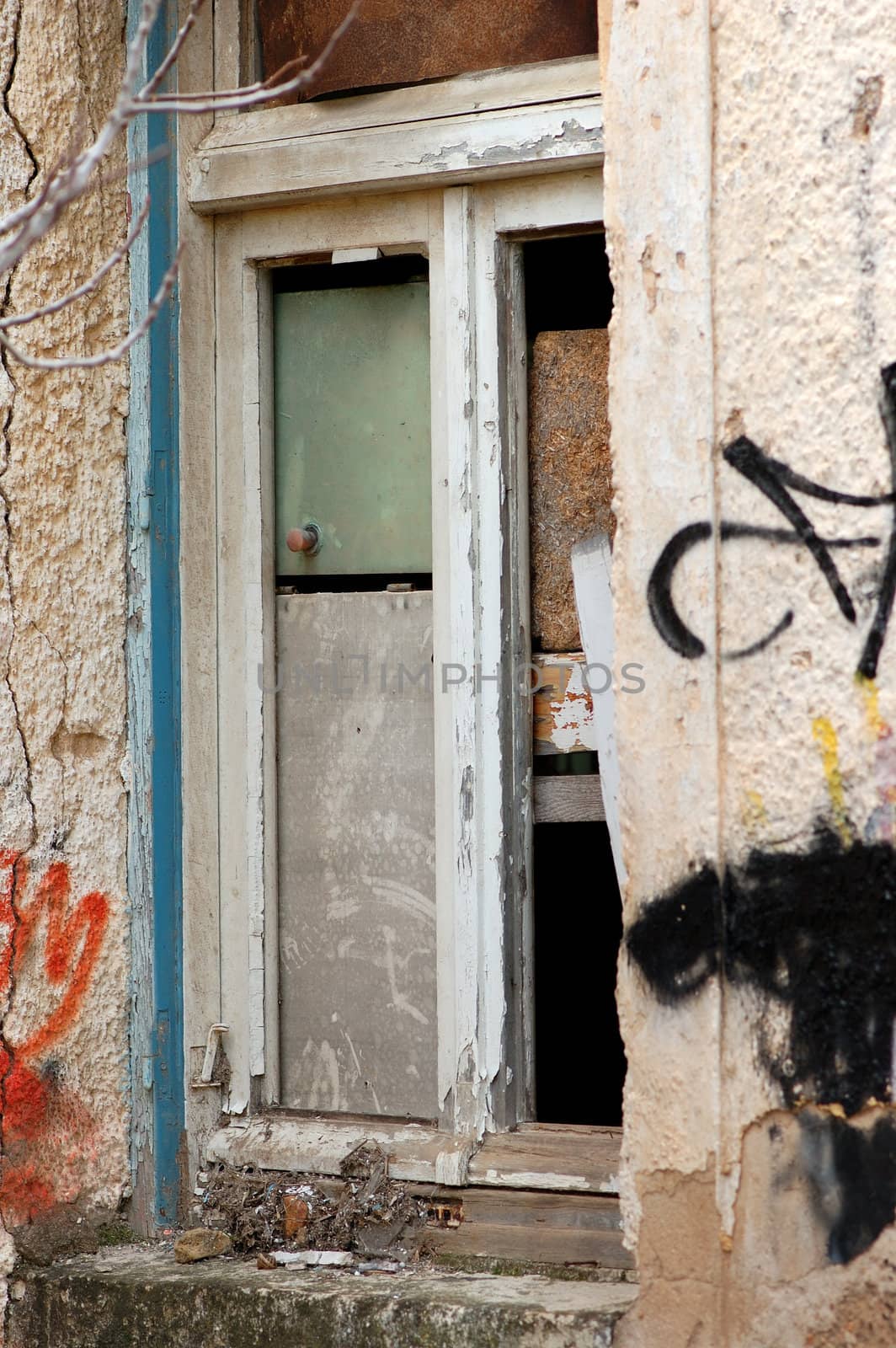 Abandoned house boarded up window detail and weathered wall.