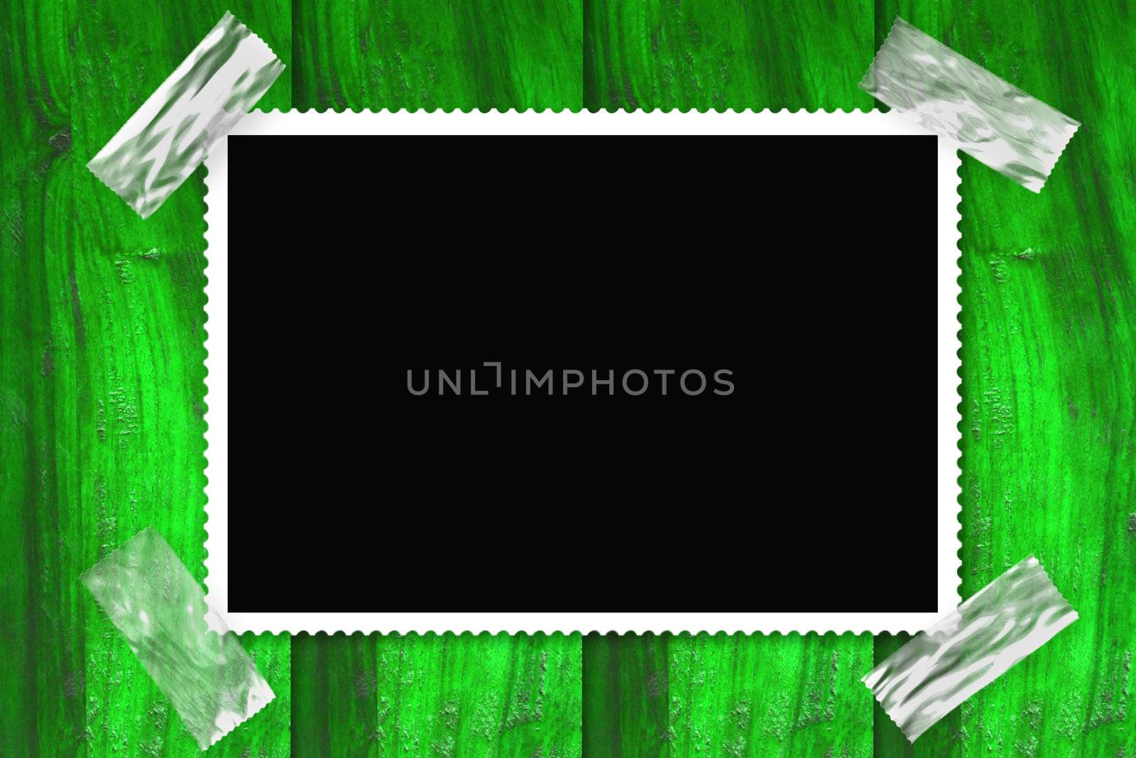 old picture frame isolated black background, stuck in a wall of green wood 