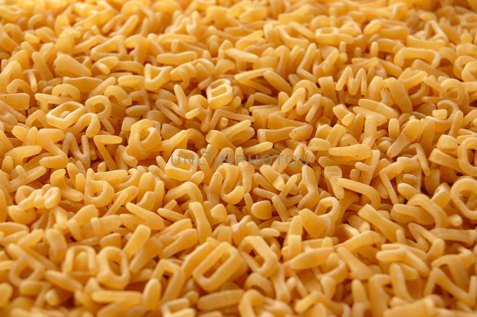 Alphabet soup letters pasta. Italian kids food background.