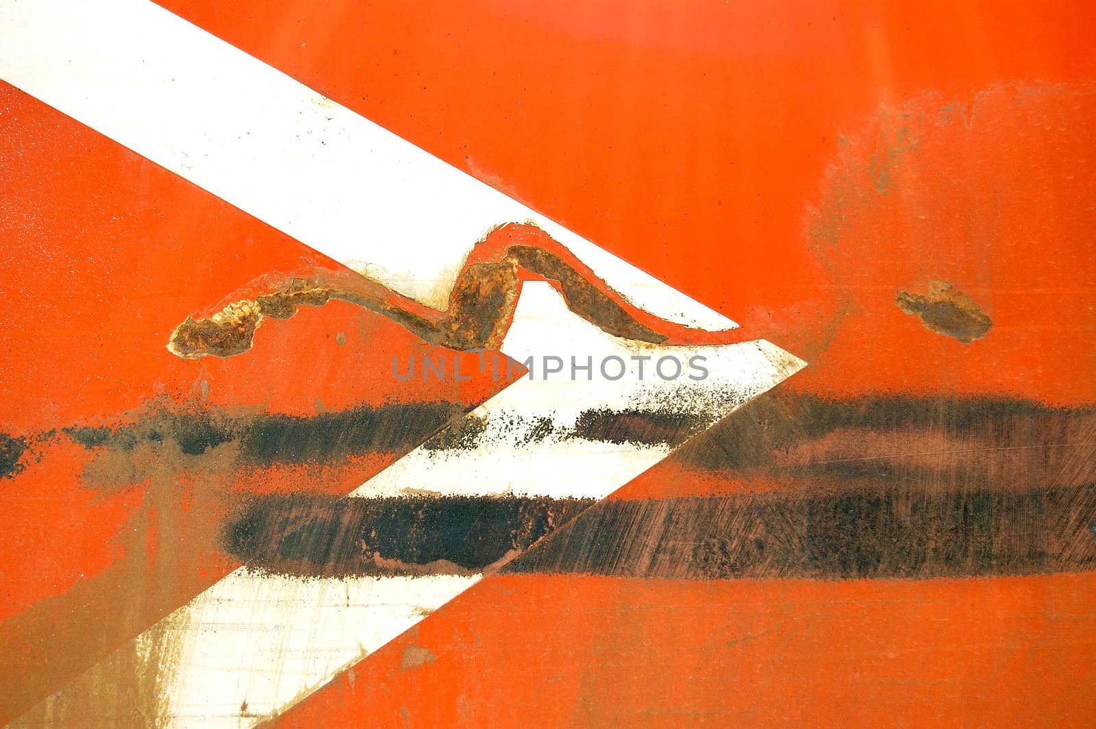 Arrow stencil on industrial metal surface. Scratched paint and rust macro background.