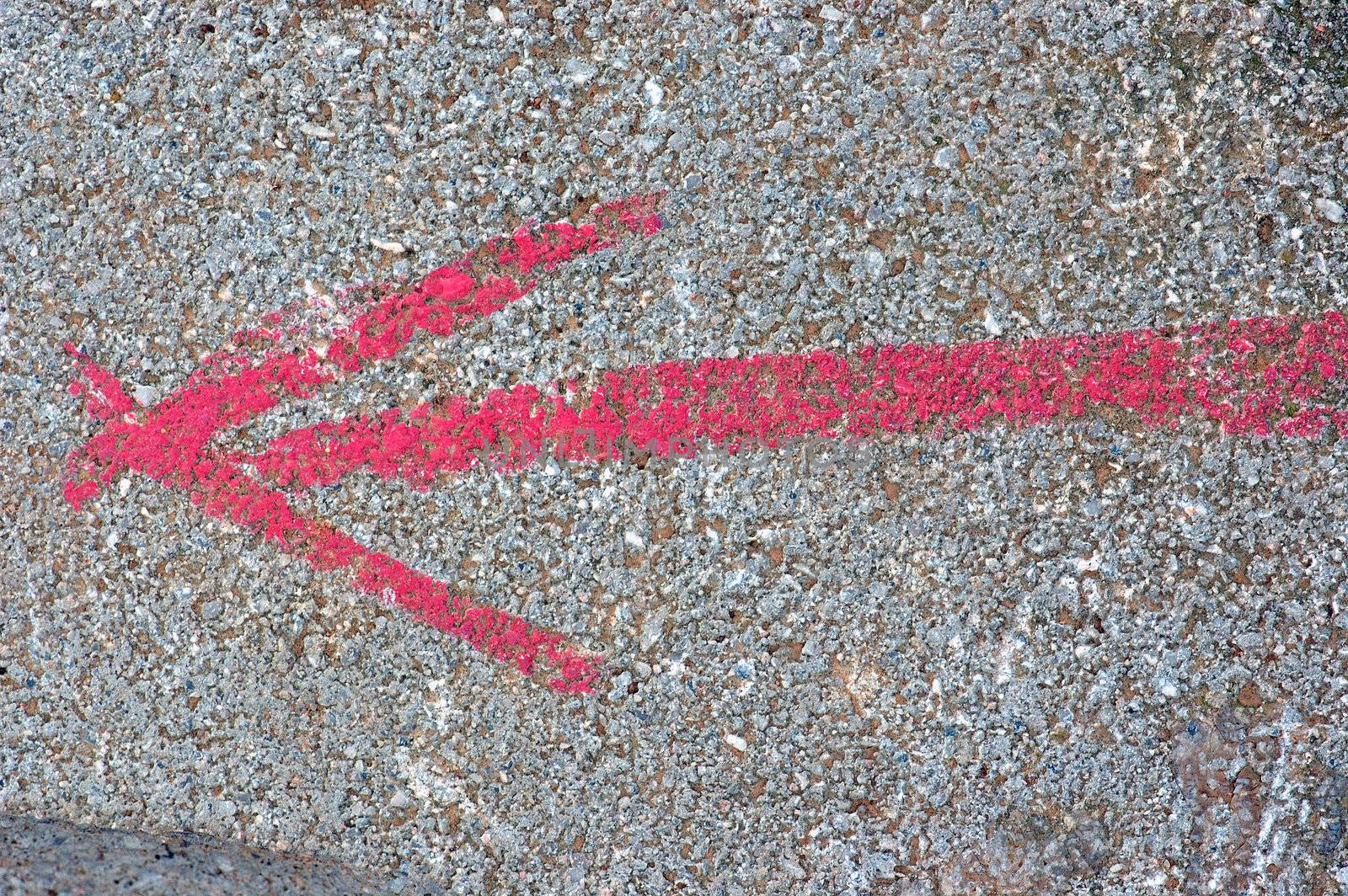 Arrow sign painted on stone surface. Abstract background texture.