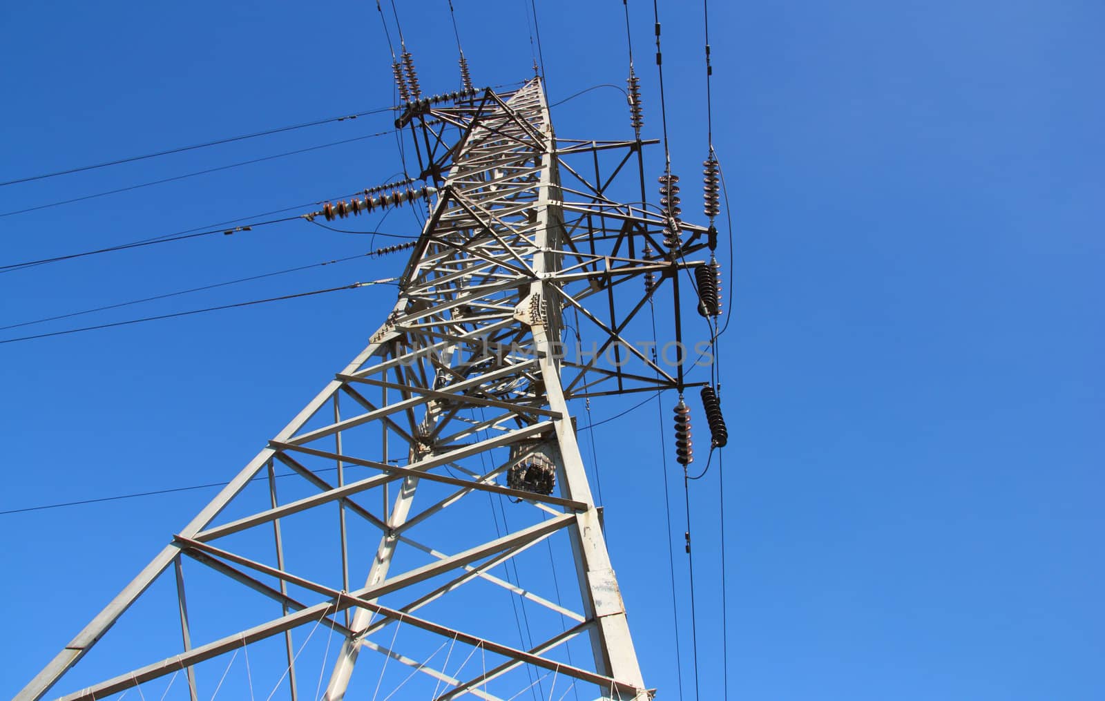 high voltage post against the blue sky