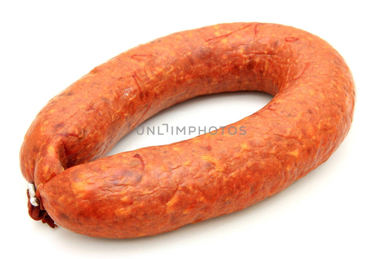 Tasty sausage is curtailed by a ring lies on a white background