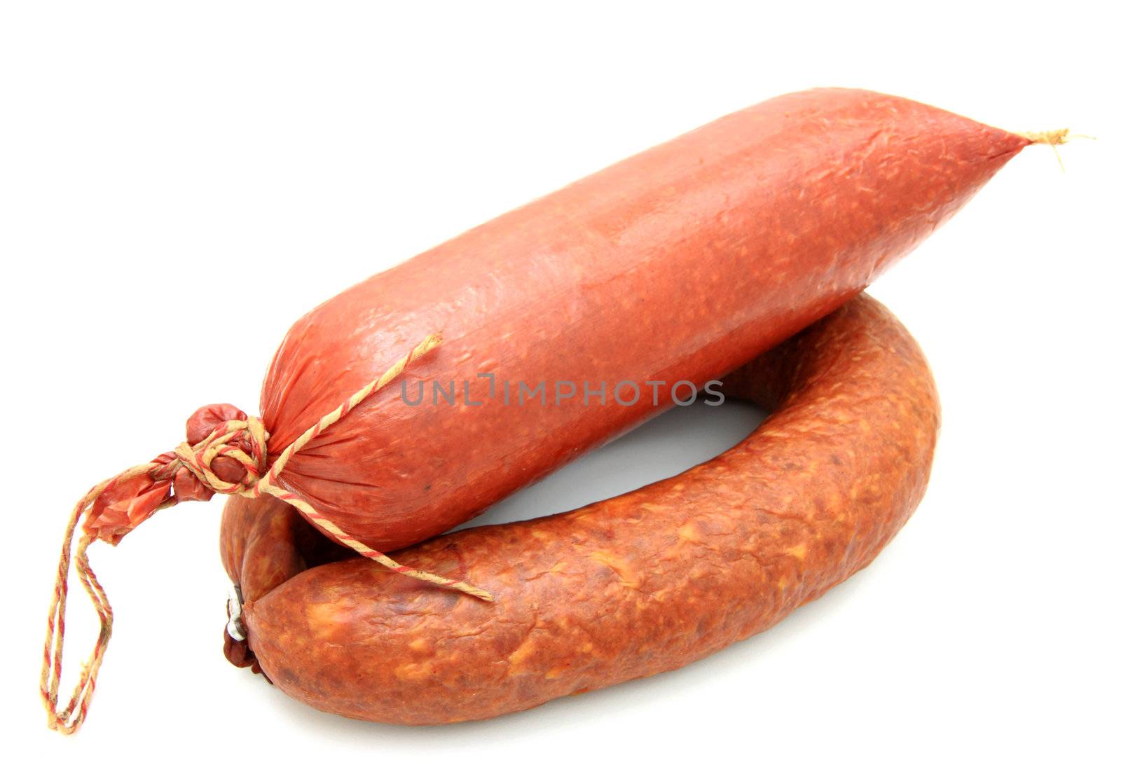 Tasty sausage is curtailed by a ring lies on a white background