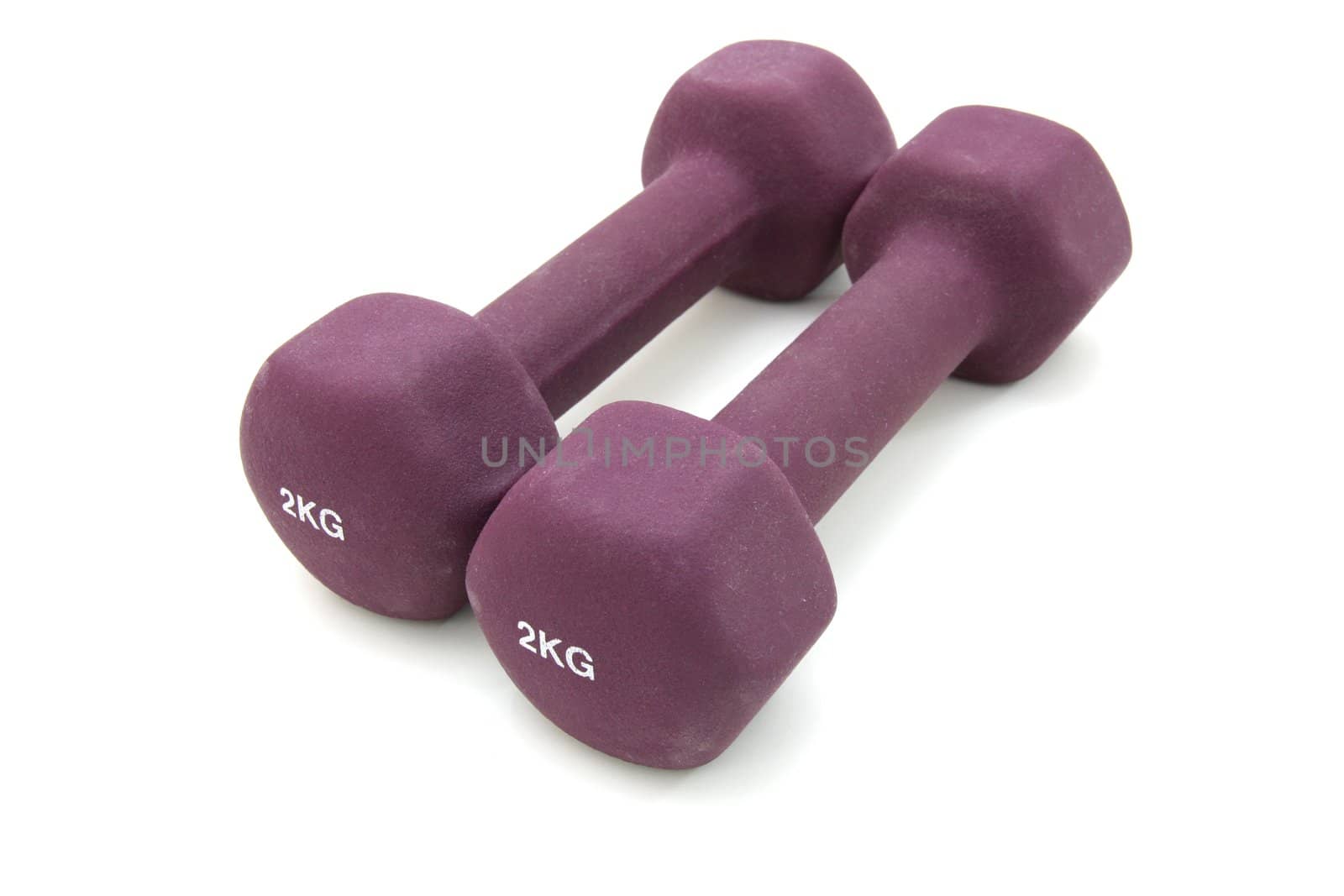 Two two kilogram dumbbells of crimson color separately on the white