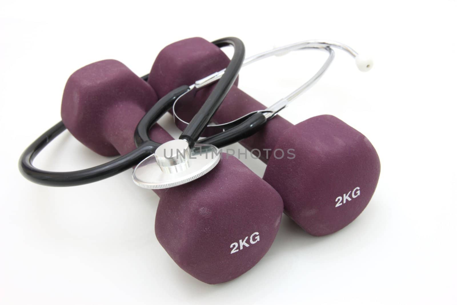 Stethoscope and dumbbell training weights together to conceptualize a healthy lifestyle.