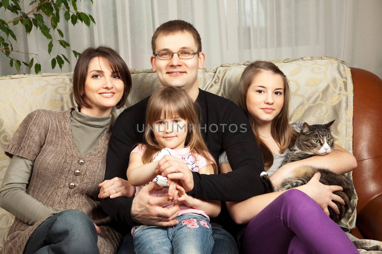 Cute family of four on their sofa at home