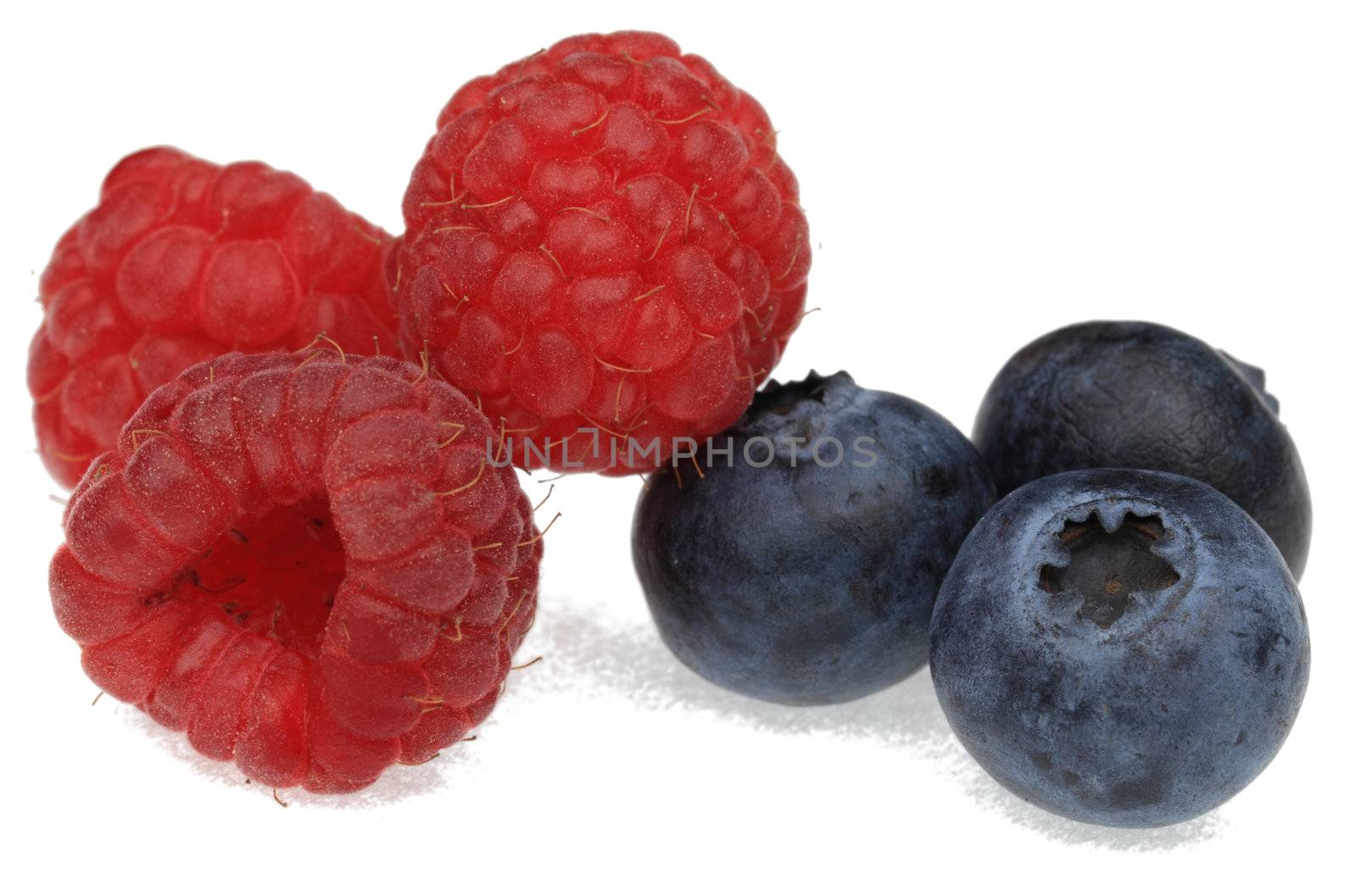 Image of blueberries and raspberries photographed in a studio against a white background.