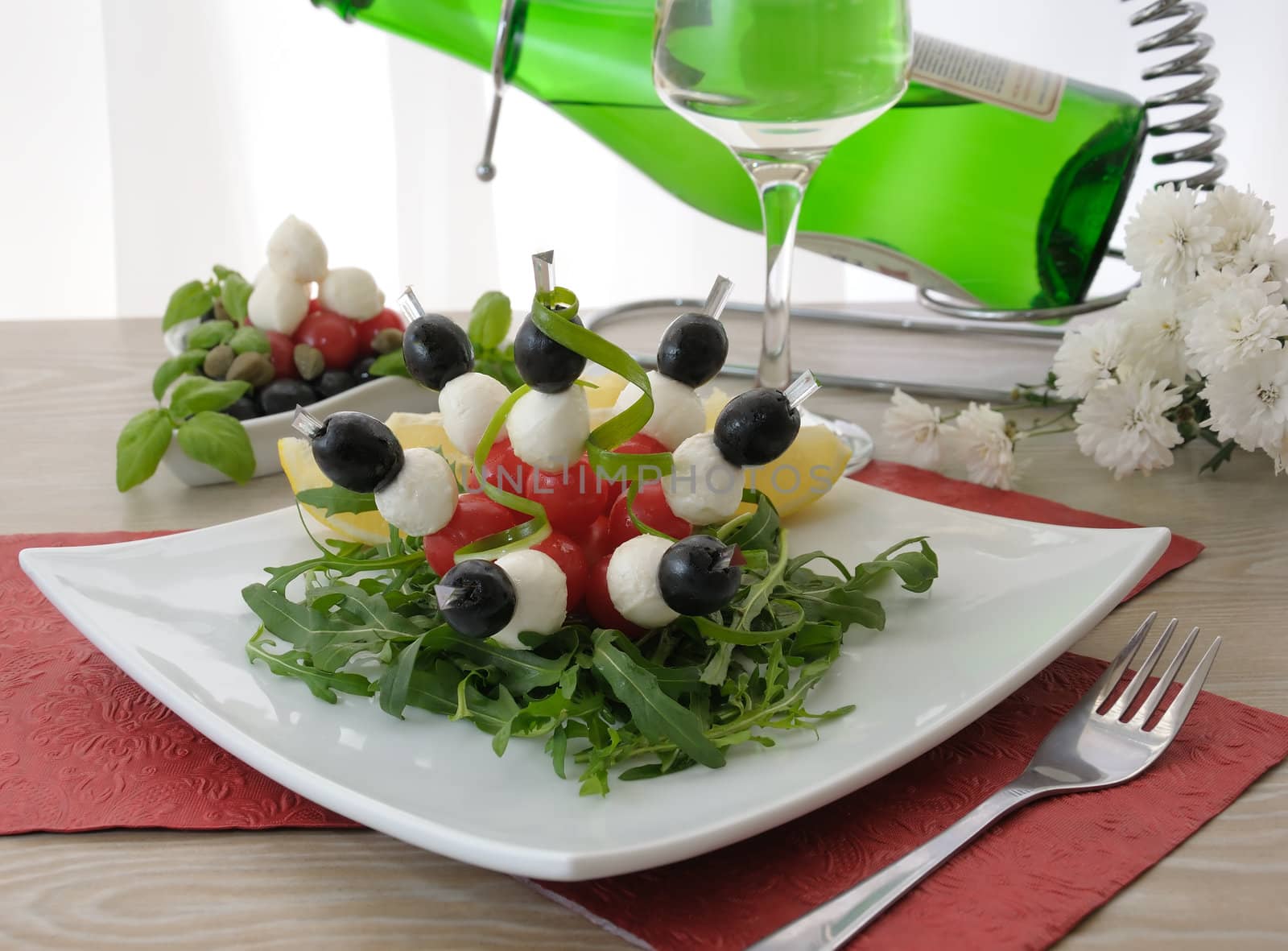 Appetizer of mozzarella, cherry tomatoes and olives with Arugula by Apolonia