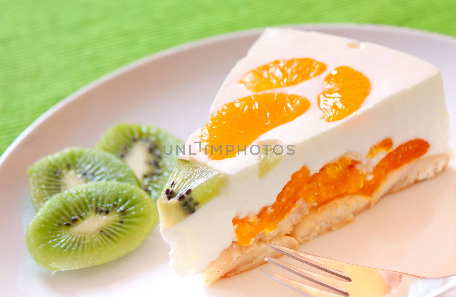 A delicious cake with clementine and kiwi on a bed of biscuits