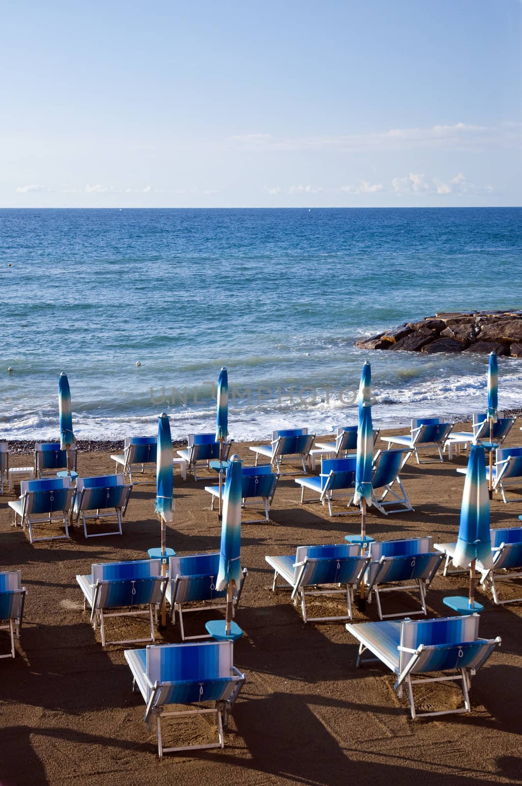 Deck chairs and umbrellas on the beach at dawn