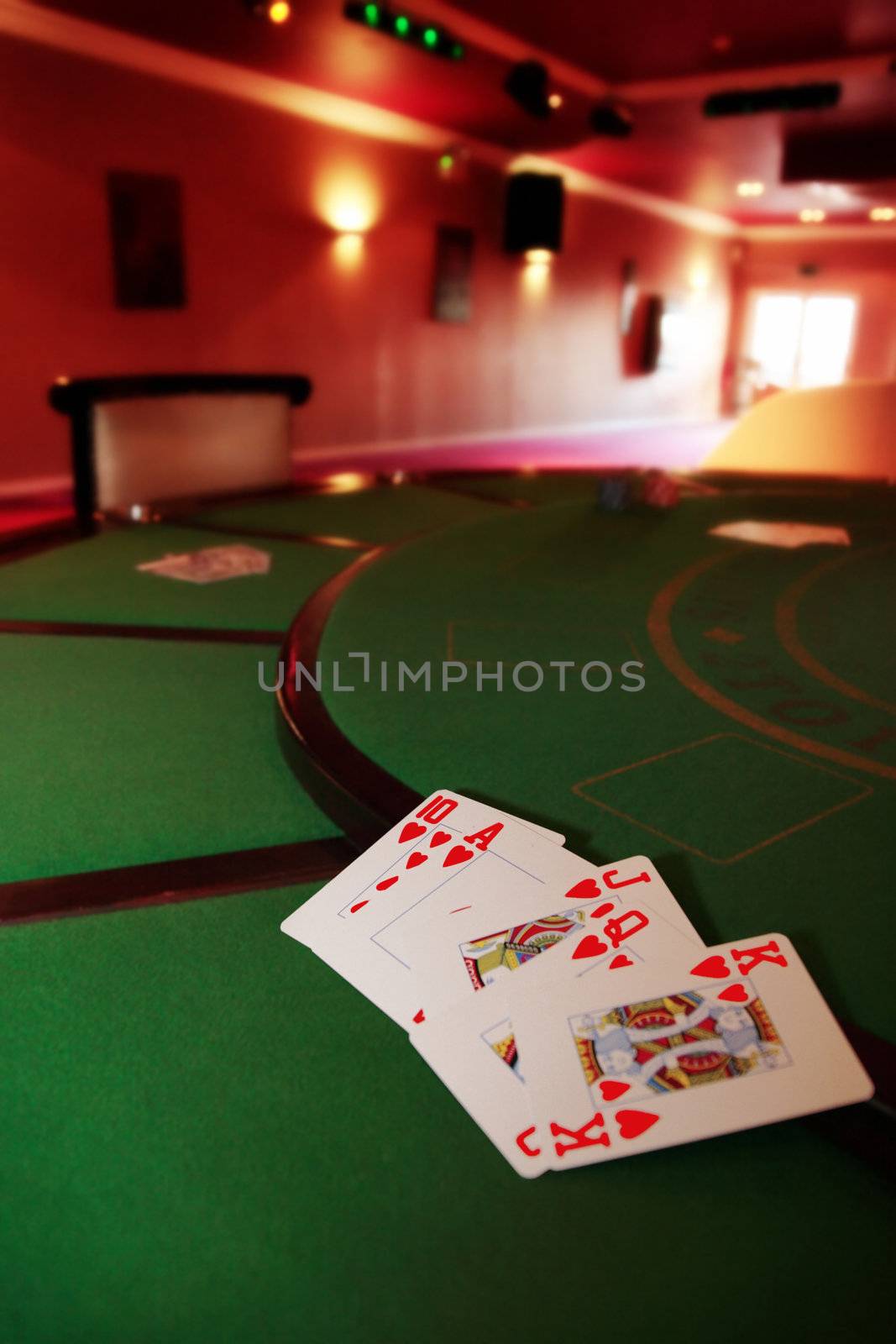 green casino table with a hand of a royal flush in a poker game