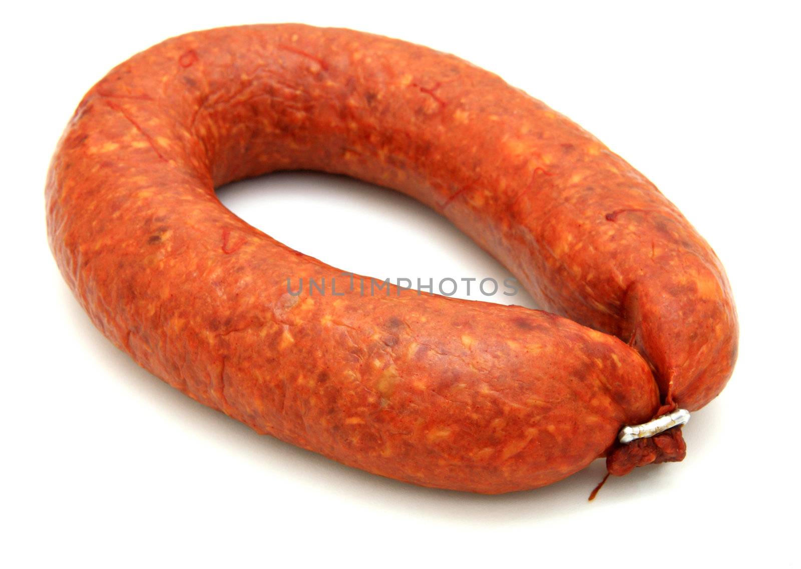 Tasty sausage is curtailed by a ring lies on a white background