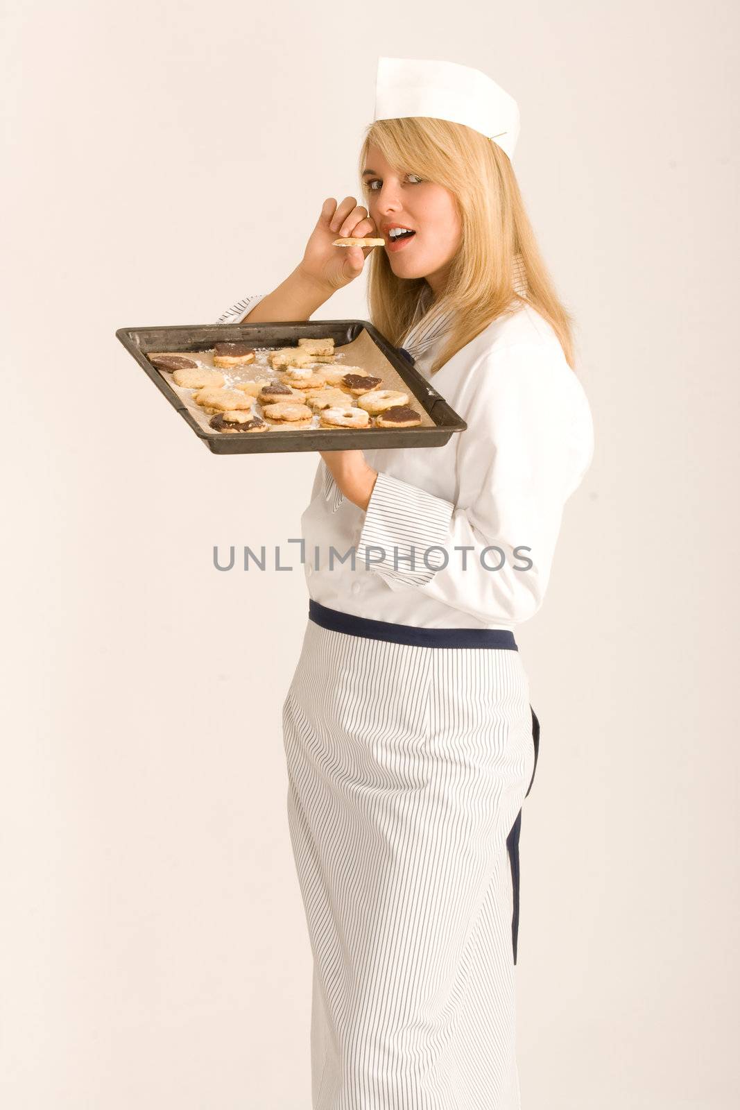 Cook nibbling on a cookie sheet full of delicious Christmas cookies