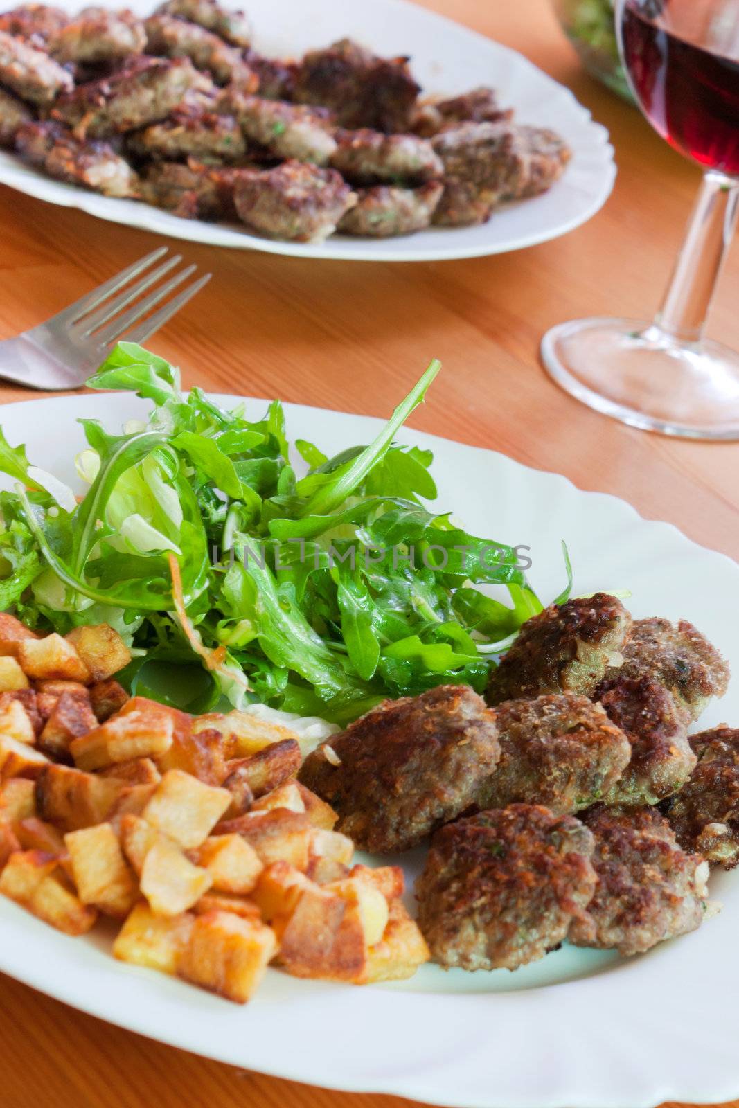 Meatballs with beef and spices, fries potatoes and salad 