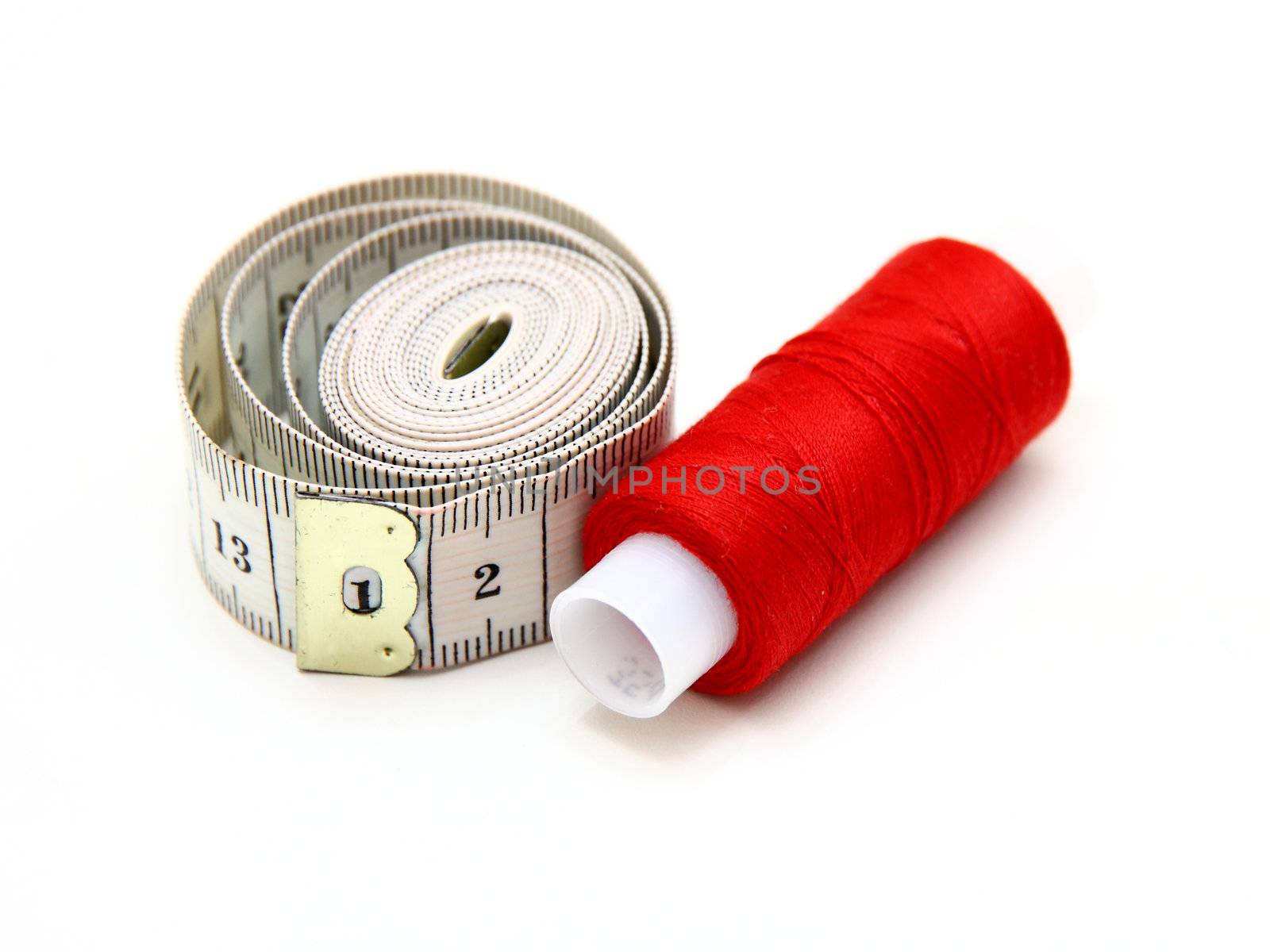The coil of a red thread with centimeter on a white background