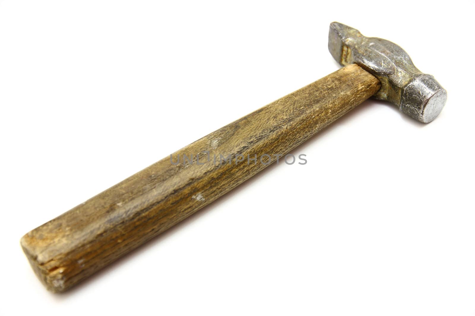 The old metal hammer with the wooden handle lies on a white background
