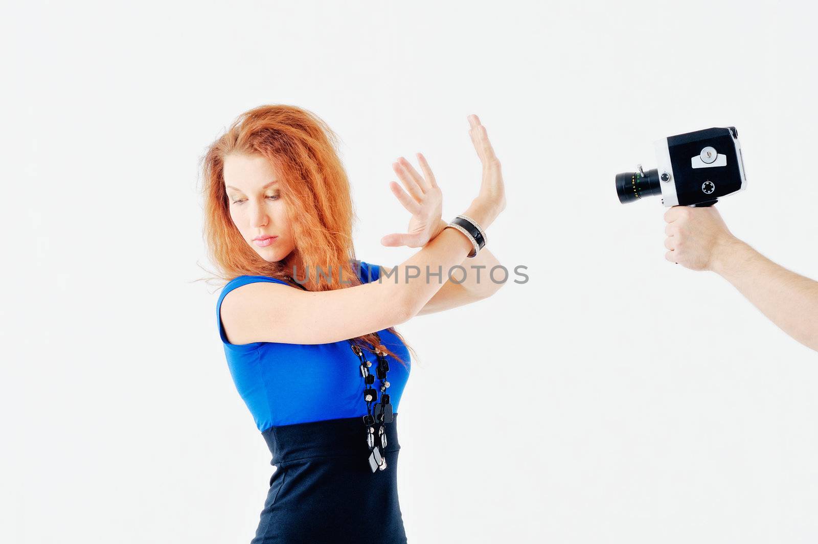 Young woman posing in front of old video camera