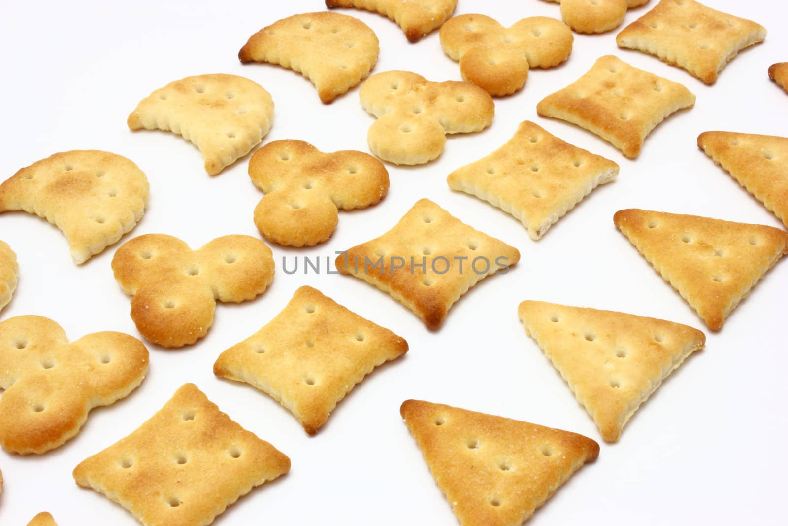 Salty crackers of the various geometrical form lie on a white background