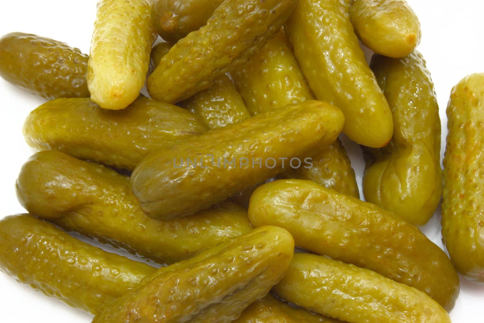 Green tasty pickles lie on a white background a small group