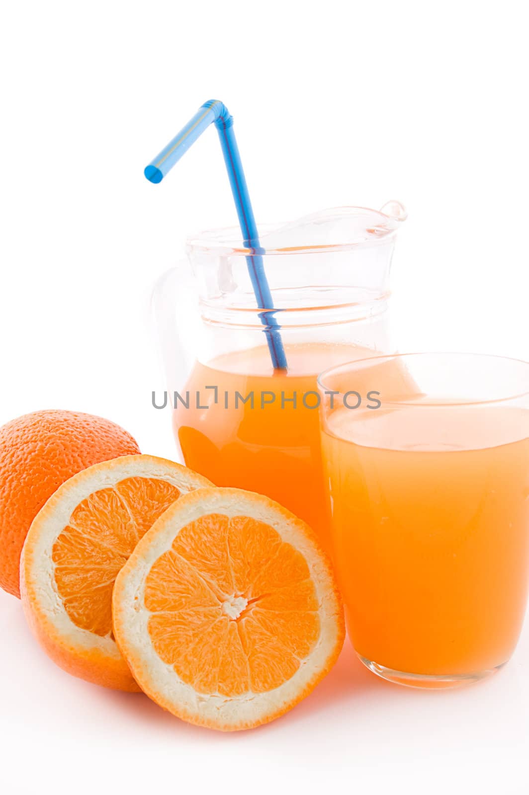 Orange juice in jug and glass with pipe over white