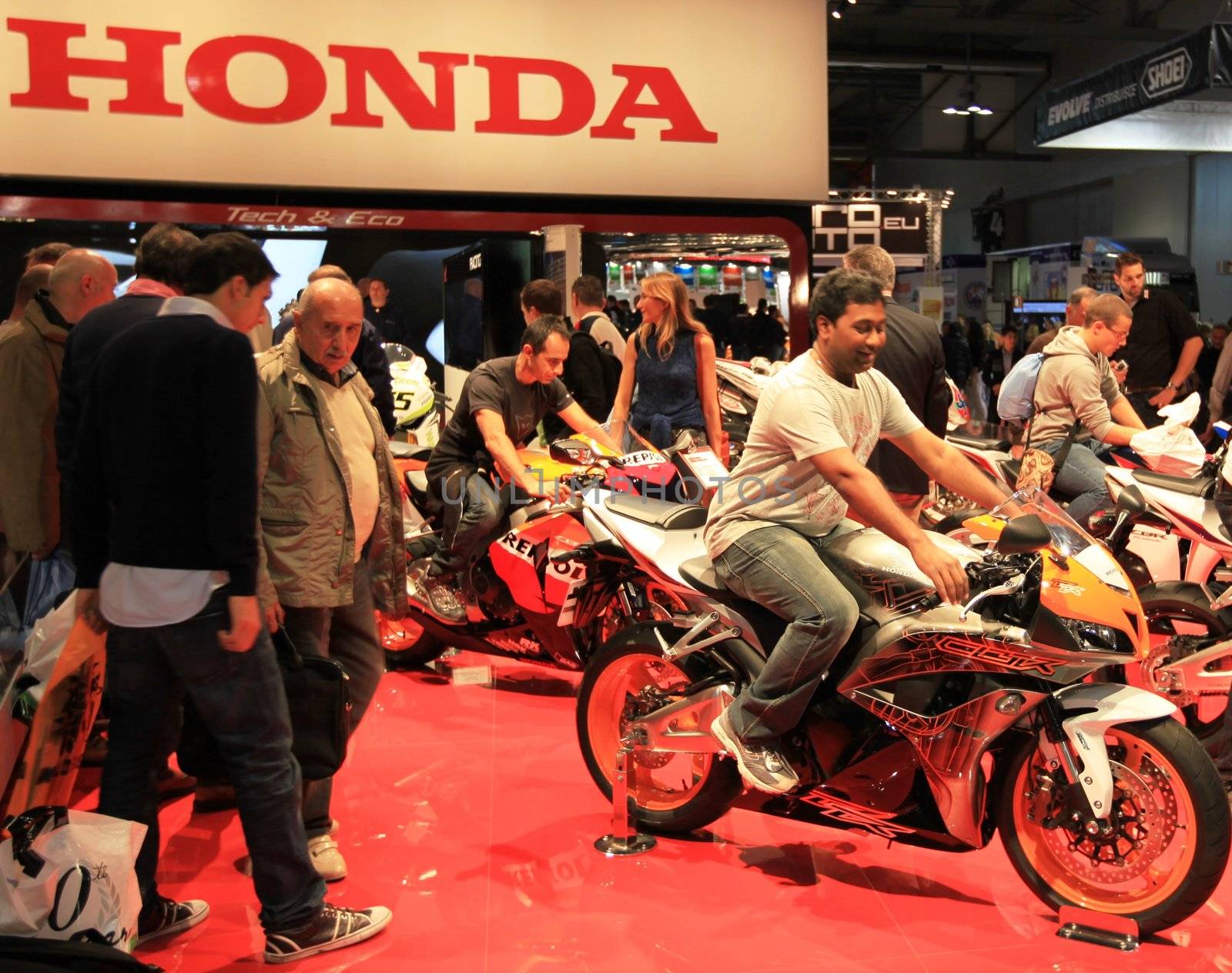 People trough Honda motorcycles exhibition area at EICMA, International Motorcycle Exhibition in Milan, Italy.