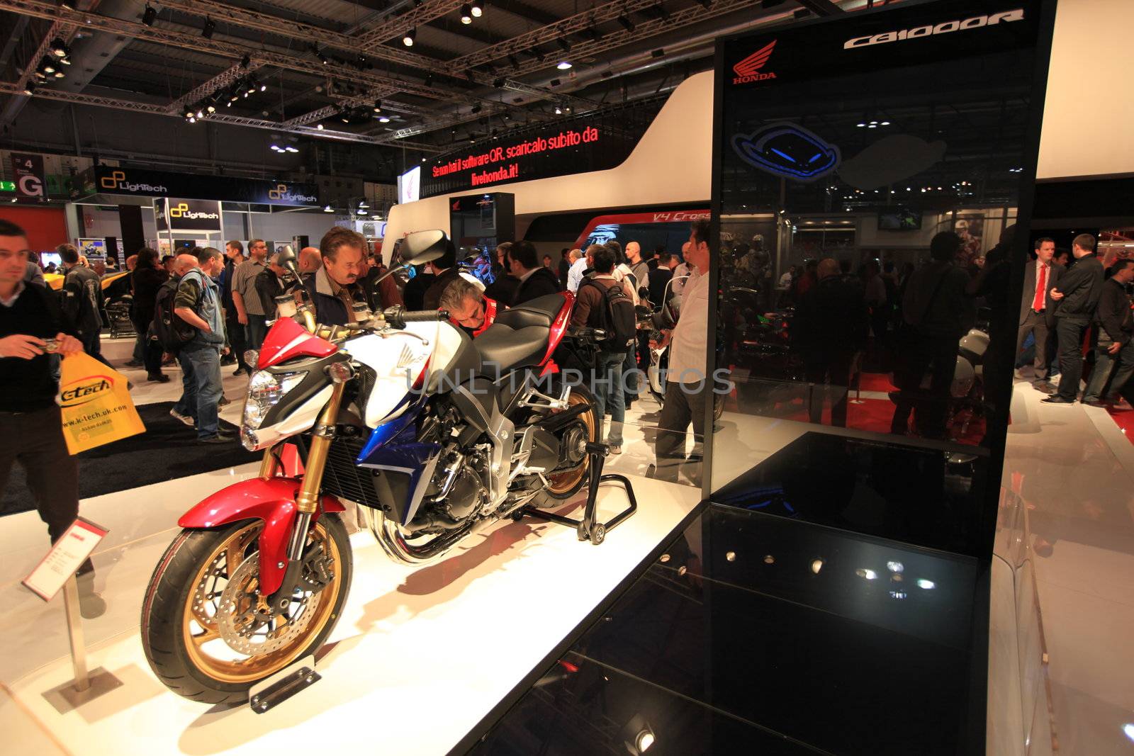 People trough Honda motorcycles exhibition area at EICMA, International Motorcycle Exhibition in Milan, Italy.