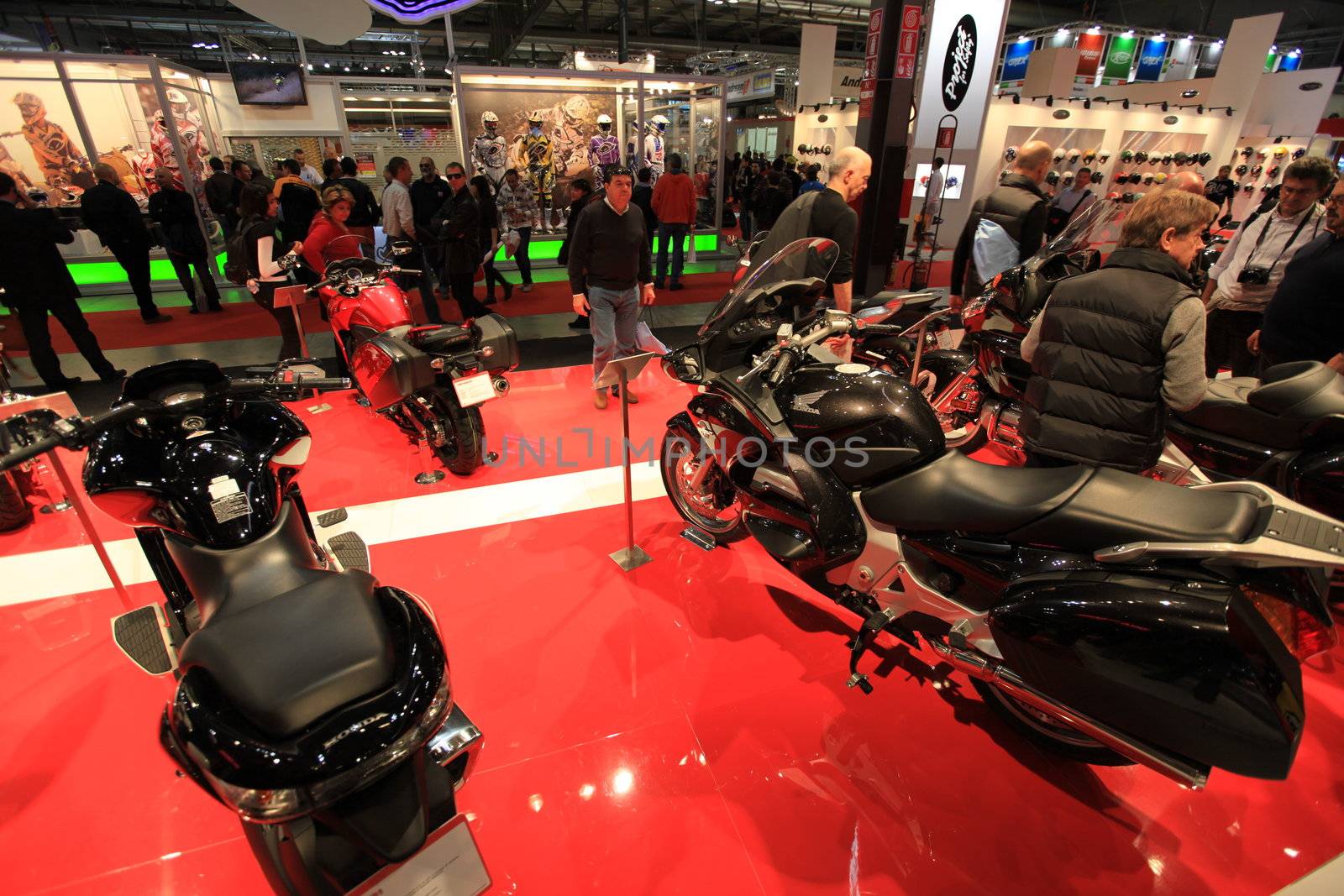 People trough Moto Guzzi motorcycles exhibition area at EICMA, International Motorcycle Exhibition in Milan, Italy.