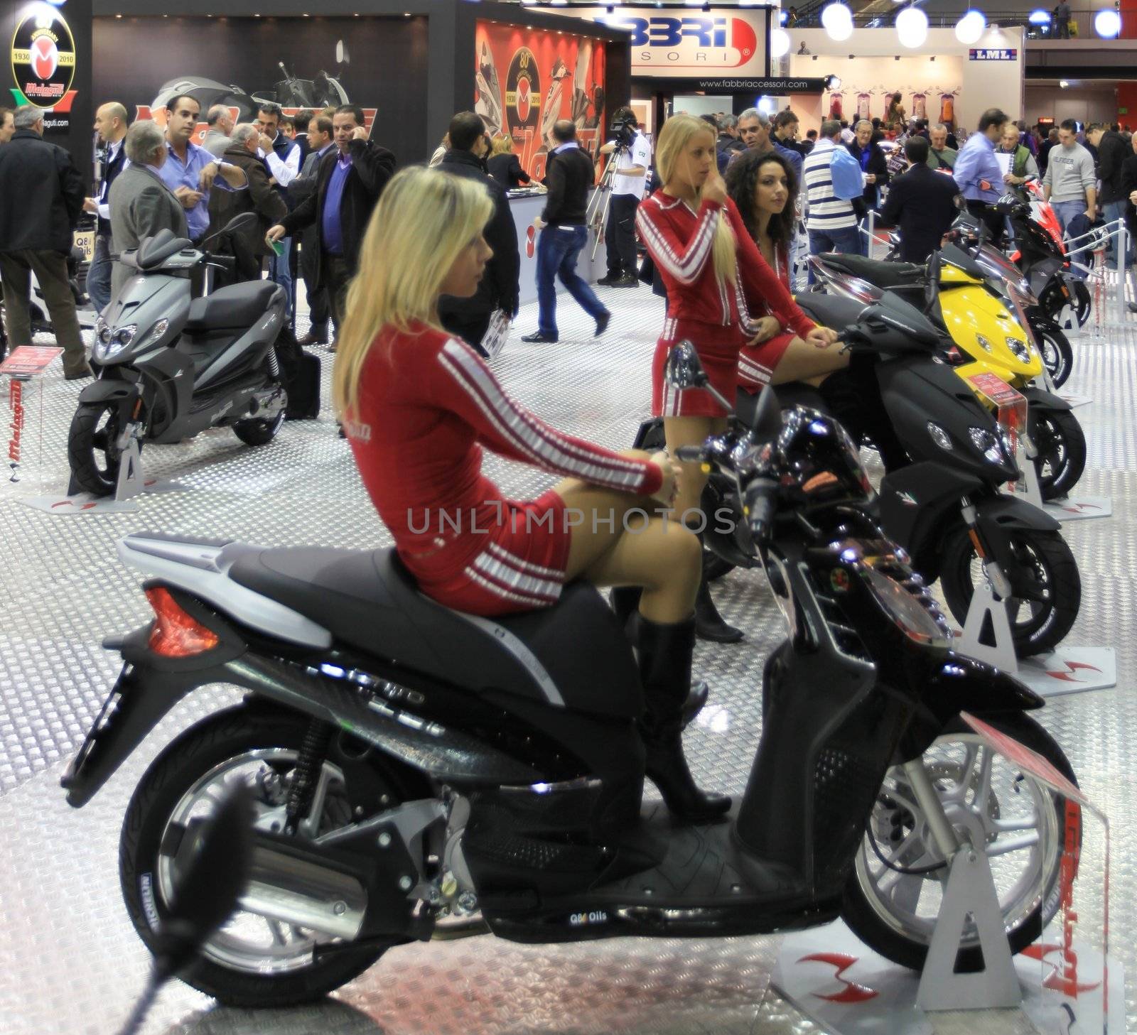 Walking trough scooters exhibition area at EICMA, International Motorcycle Exhibition in Milan, Italy.