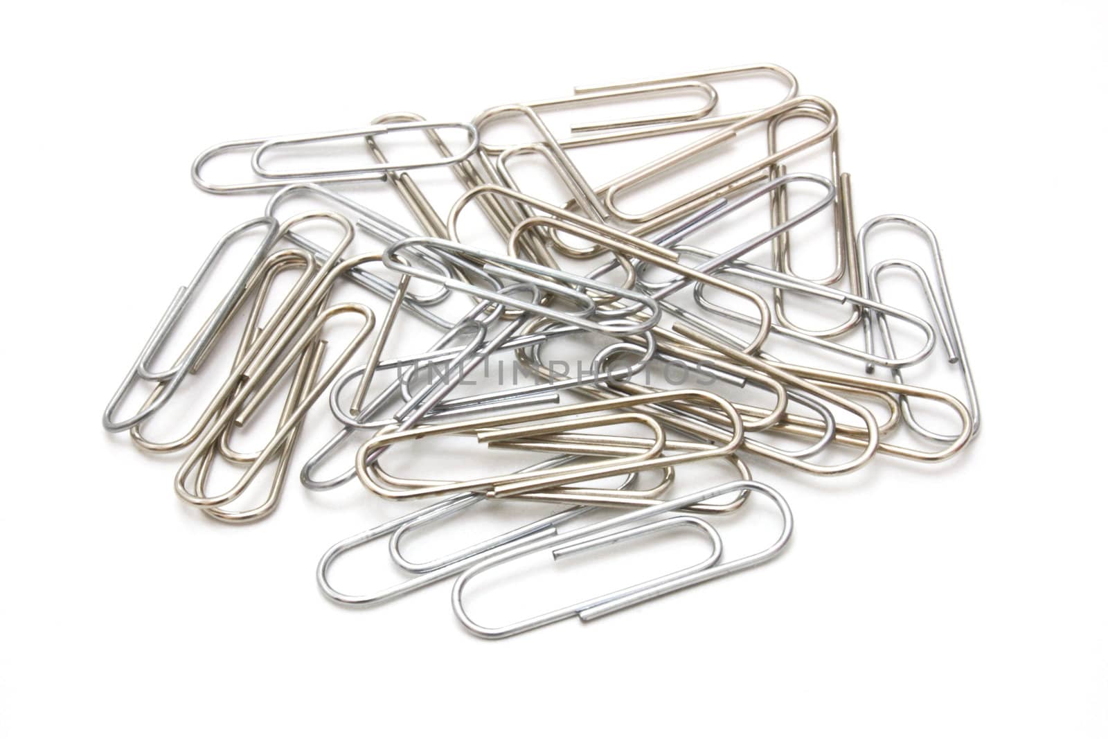 Writing metal paper clips lie in bulk on a white background of a paper