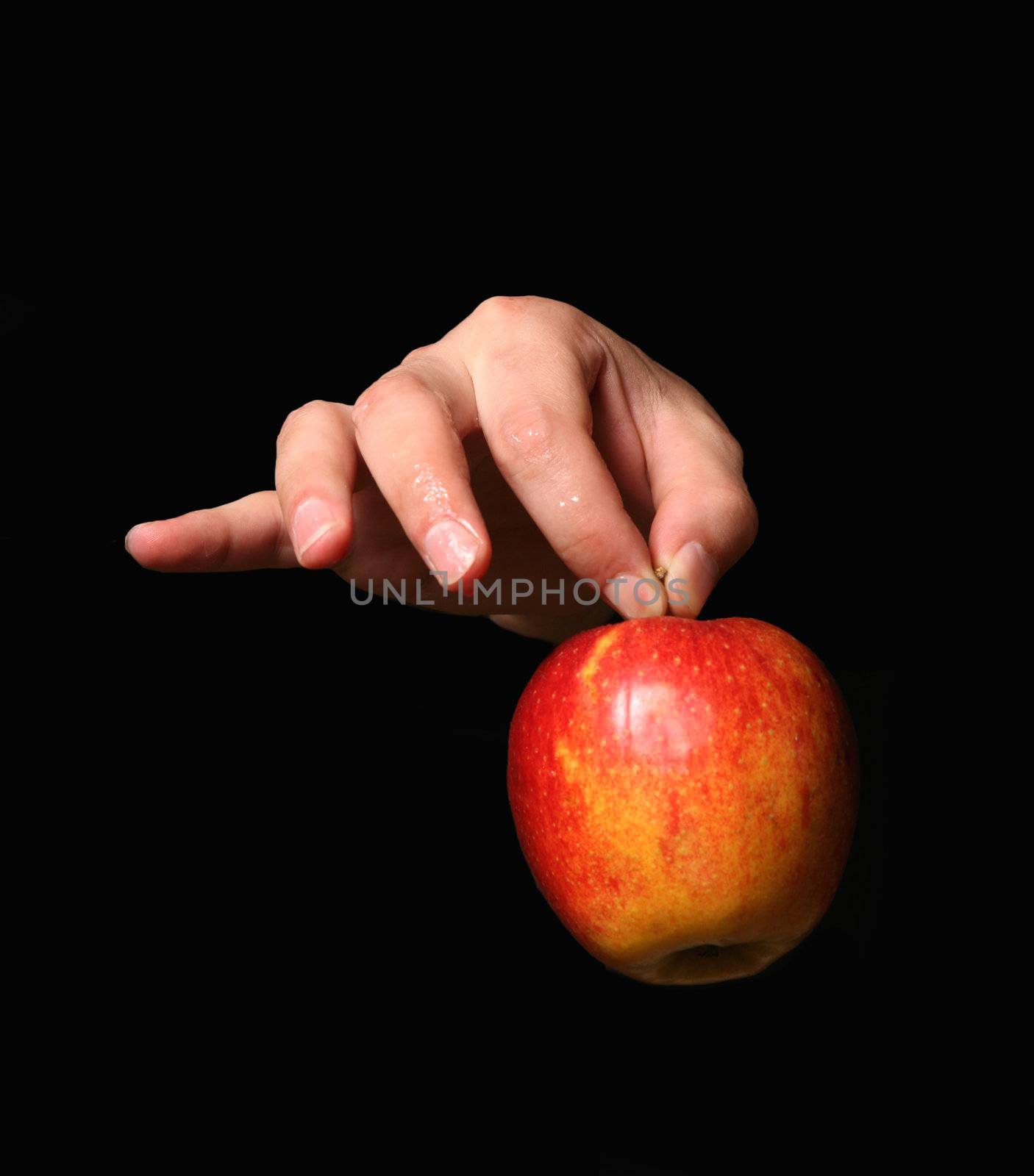 Man's hand with a red apple on a black background