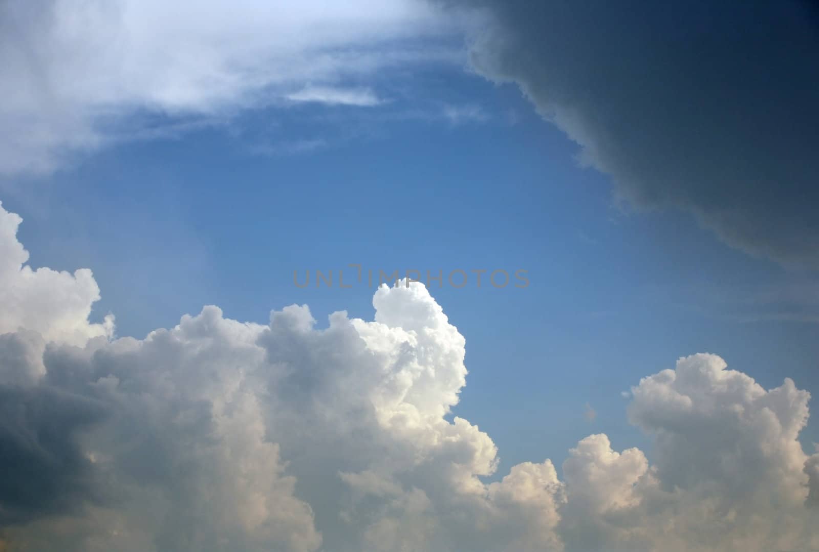 The image of white clouds on a background of the dark blue sky