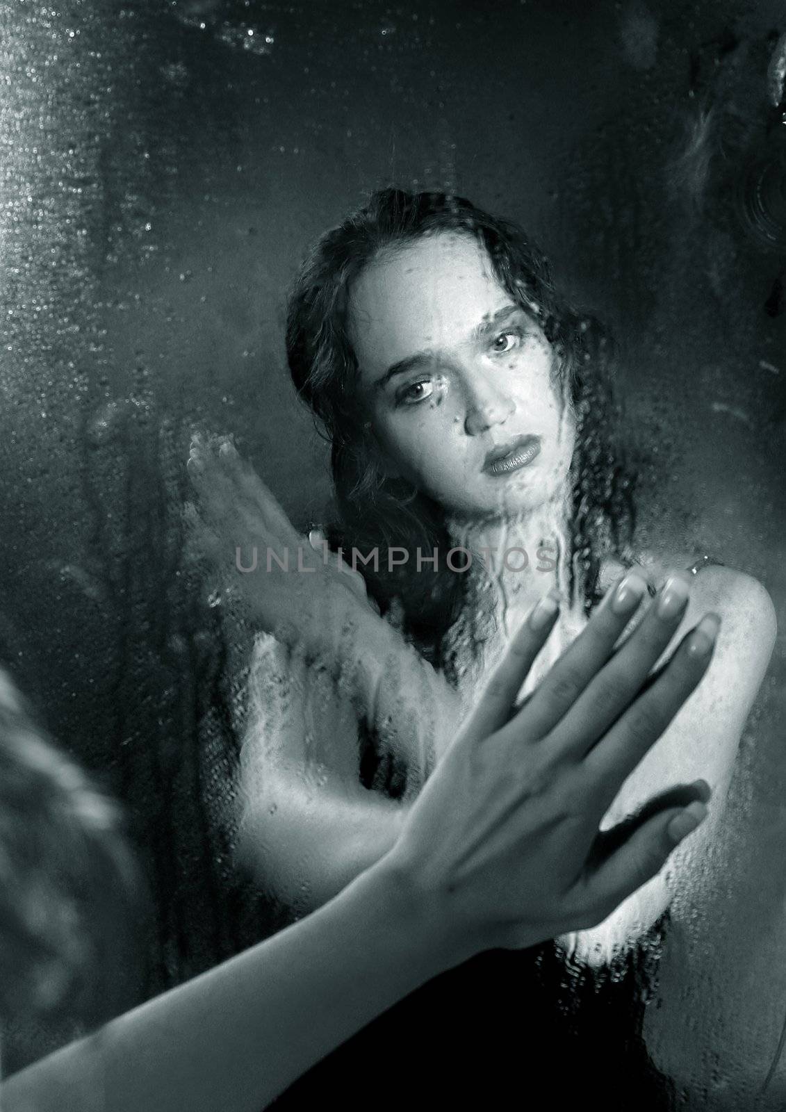 Portrait of the woman in reflection of a wet mirror