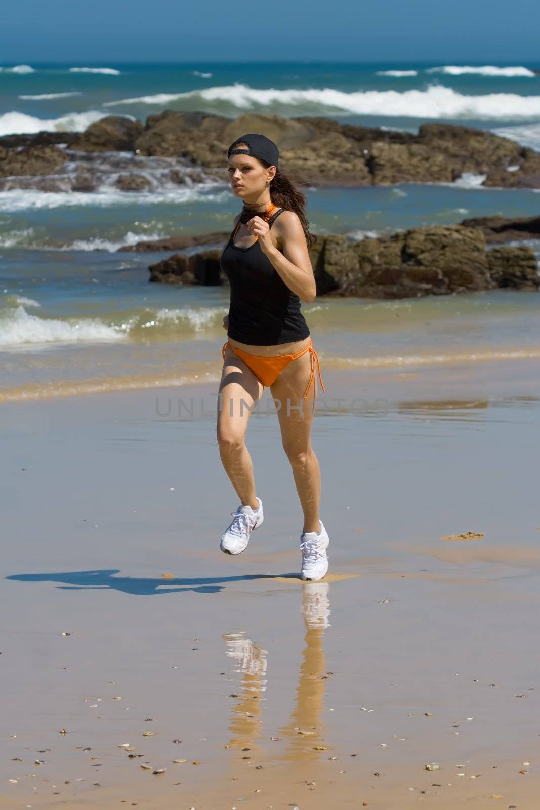 Athletic model running fast on the beach
