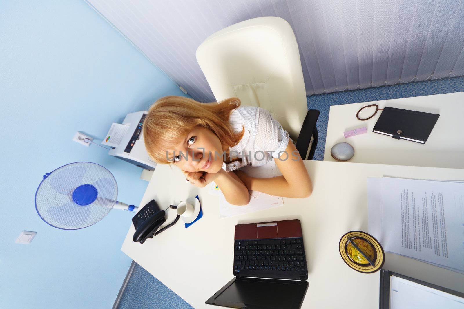 Funny young woman sitting in an office at a desk