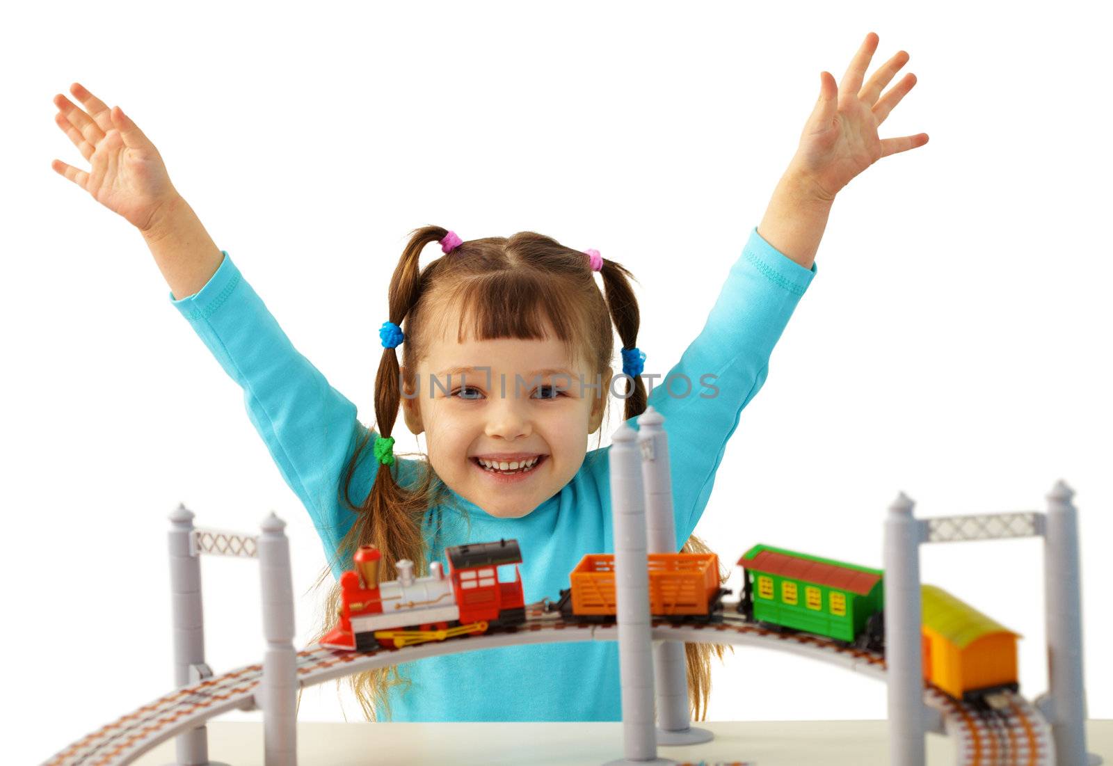 Joyful girl playing with a toy railway isolated on white background