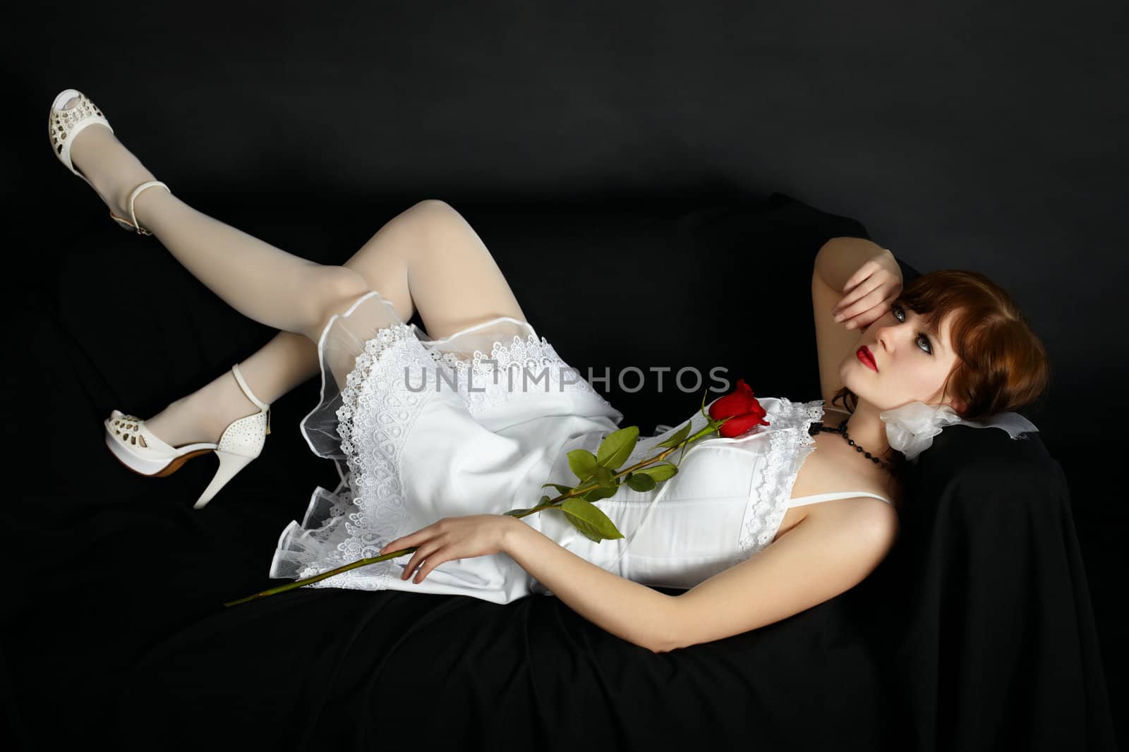 Attractive woman in white dress lying on black couch by pzaxe