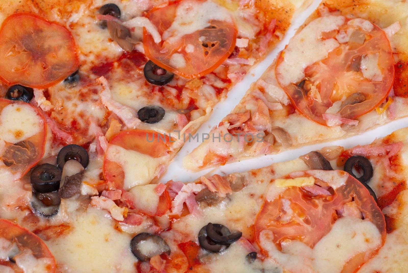 meat pizza closeup with carbonado ham, tomato, olive and mozzarella cheese