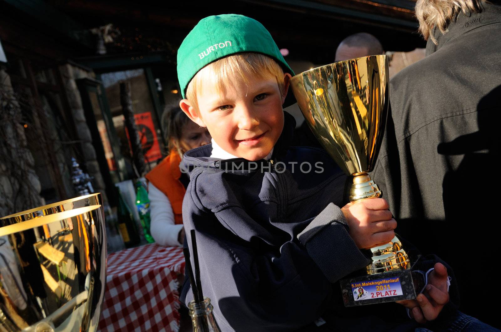 KAPRUN AUSTRIA - MARCH 5: Maiskogel Fanlauf 2011. Unidentified boy holding his trophy at charity ski race with many celebrities in austria on March 5, 2011 at the Maiskogel in Kaprun, Austria