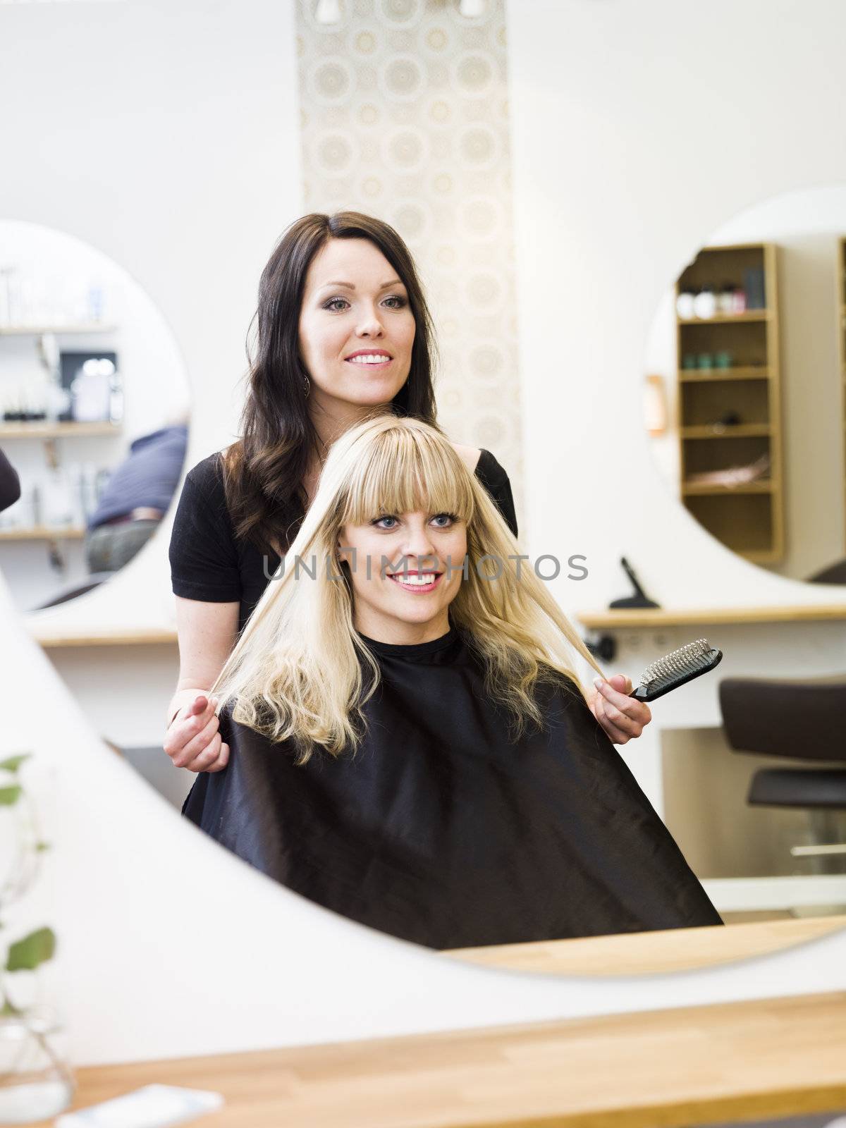 Hairdresser in action with blond customer close up