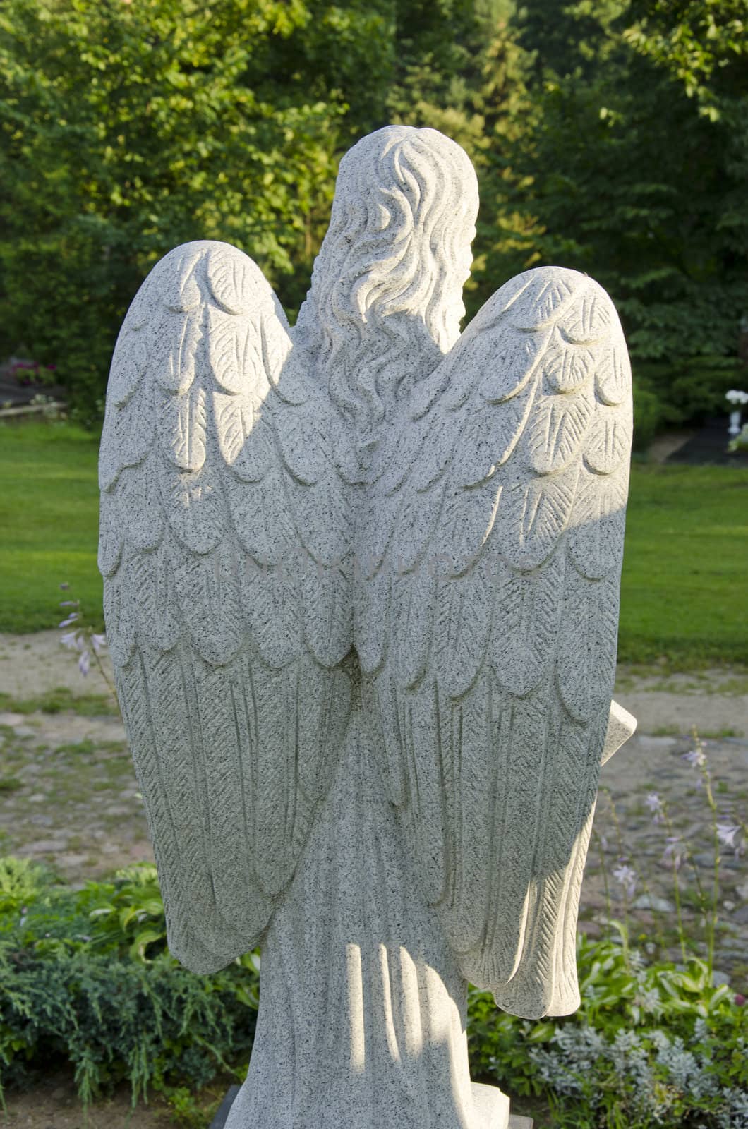 Angel sculpture from behind. Huge wings. Religious statue.